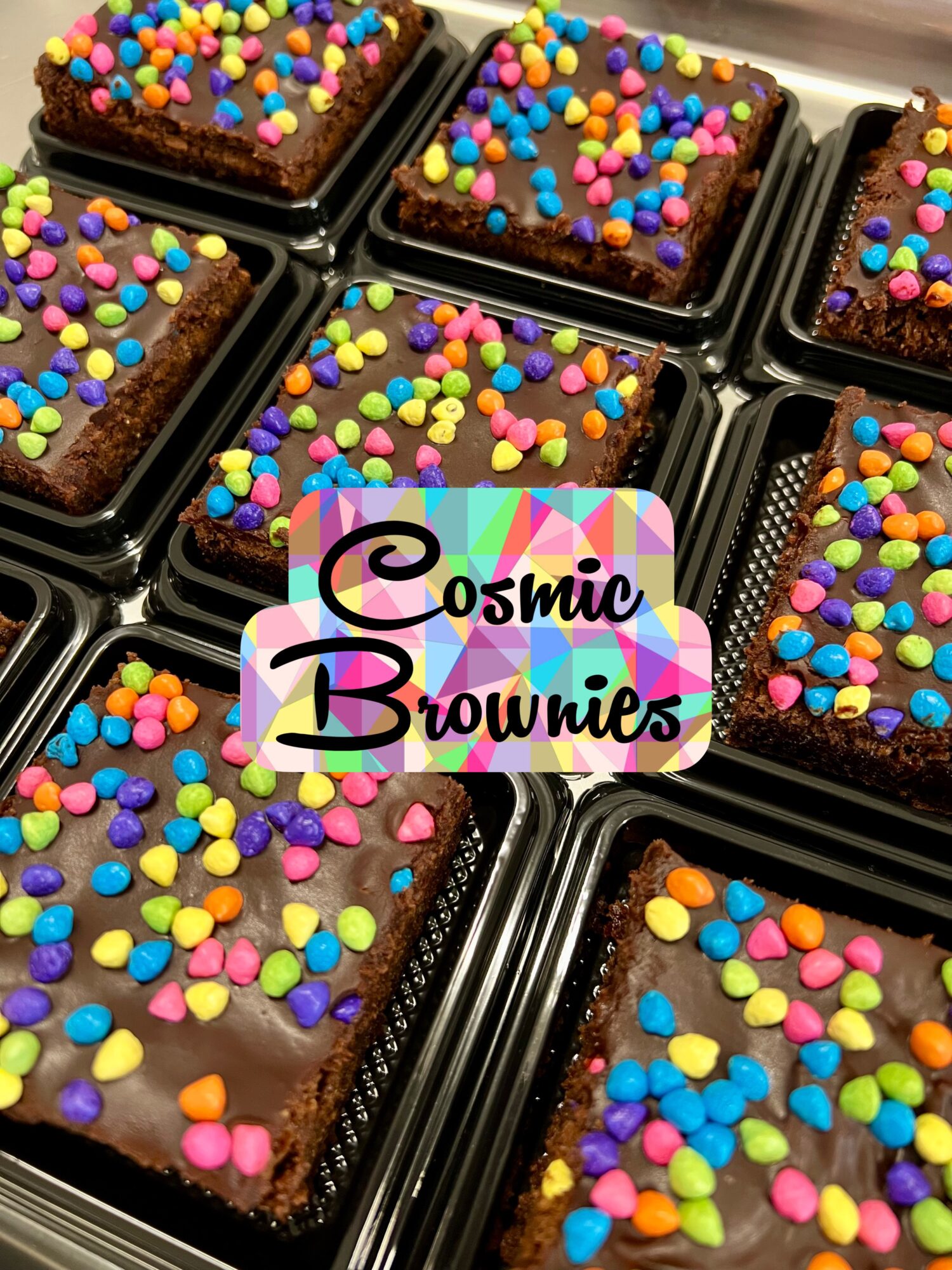 Chocolate brownies topped with colorful heart-shaped sprinkles in black trays.