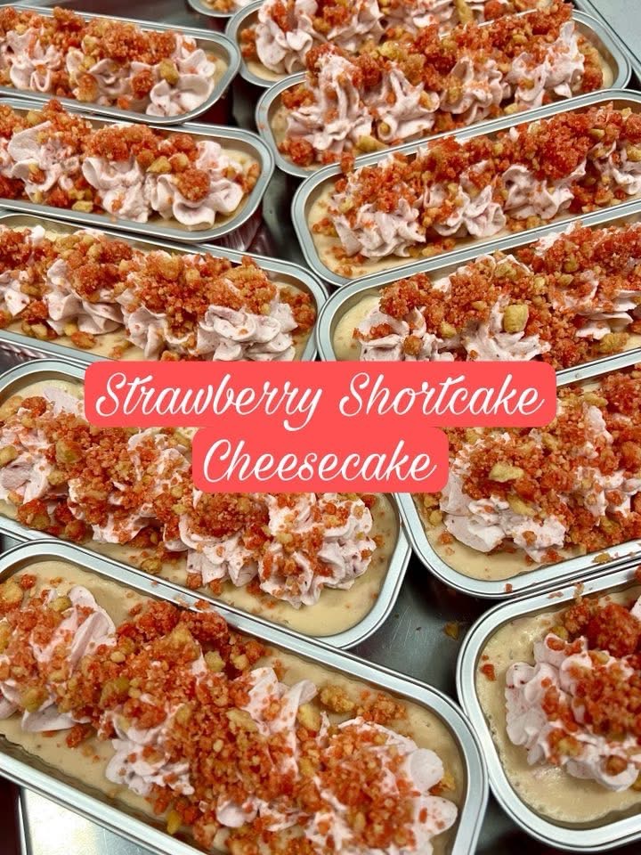 Multiple strawberry shortcake cheesecakes in oval dishes topped with crushed cookies and strawberries, with a pink overlay text.