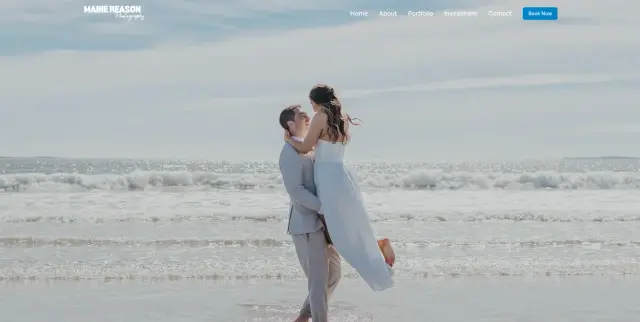A couple on the beach, with the man lifting the woman, ocean waves in the background, cloudy sky, and light-colored sand.