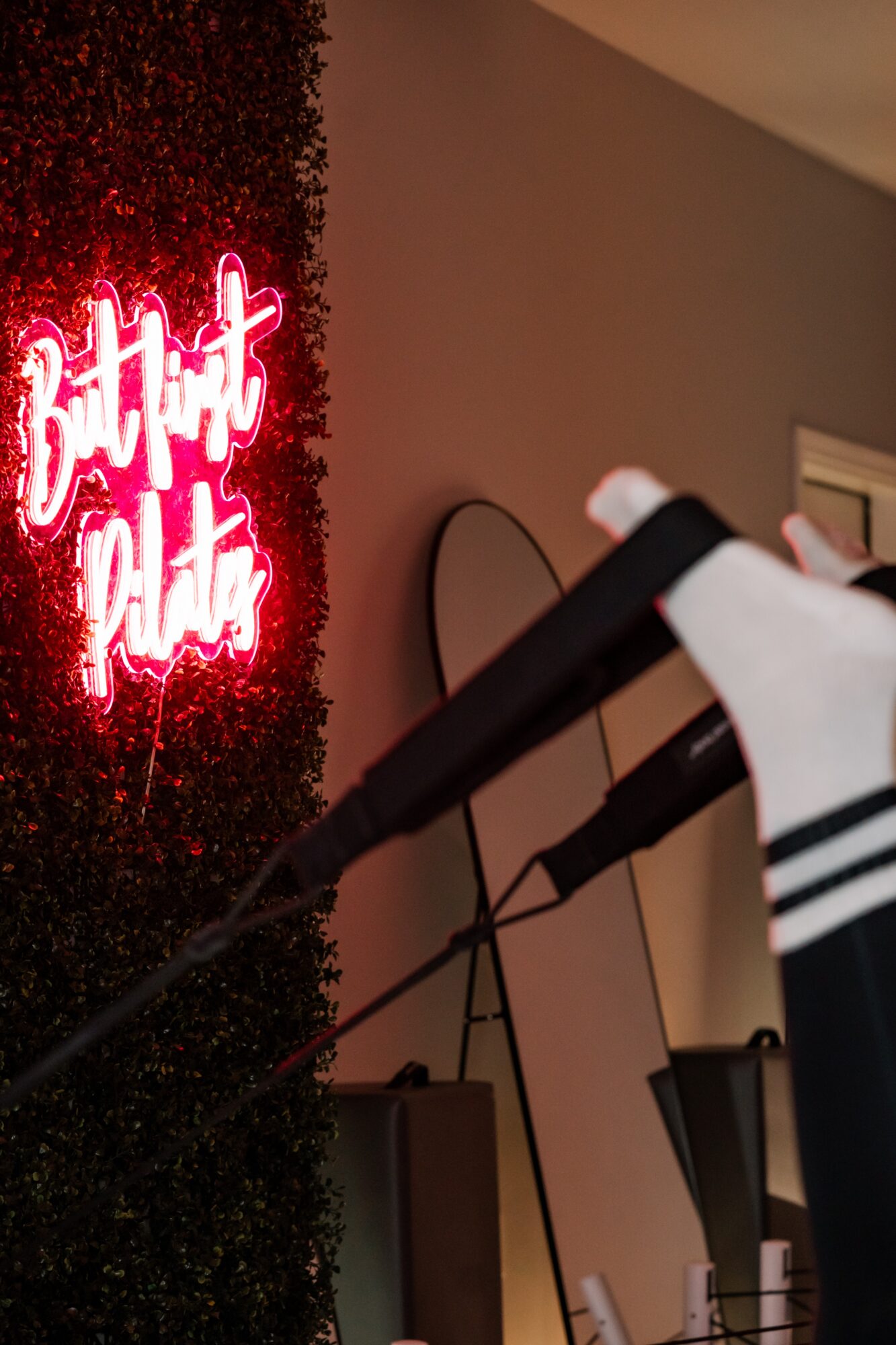 Person holding a golf club indoors near a neon sign that says 'Bright Lights'.