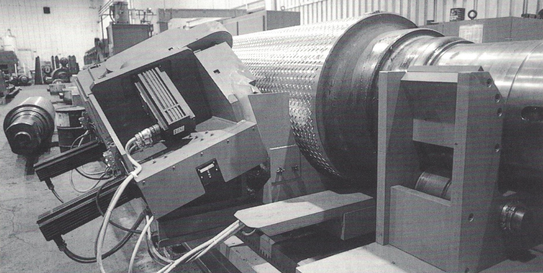 Industrial machinery with electronic components and large cylindrical parts in a factory setting.