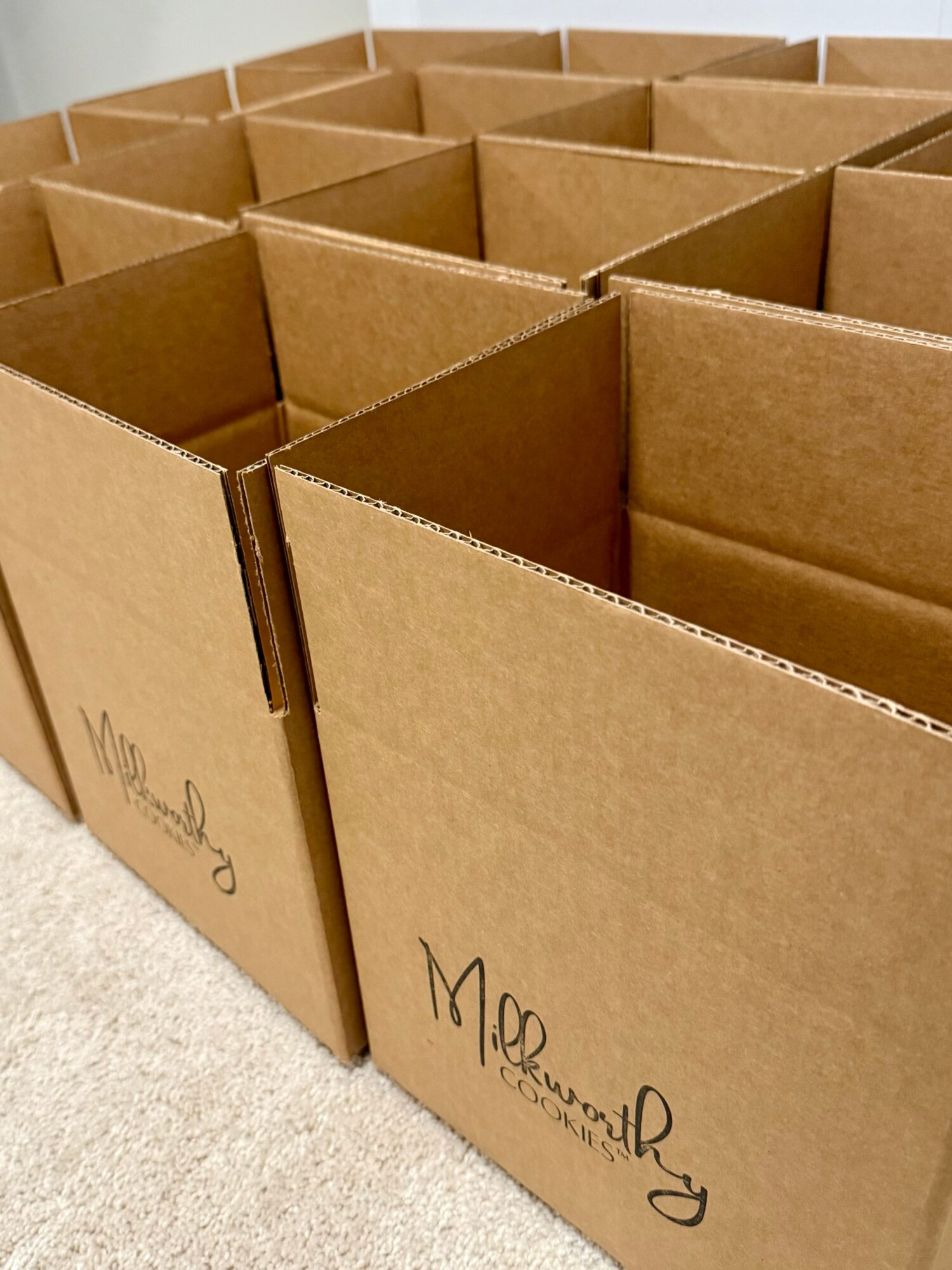 Multiple empty cardboard boxes arranged in rows on a light-colored surface.