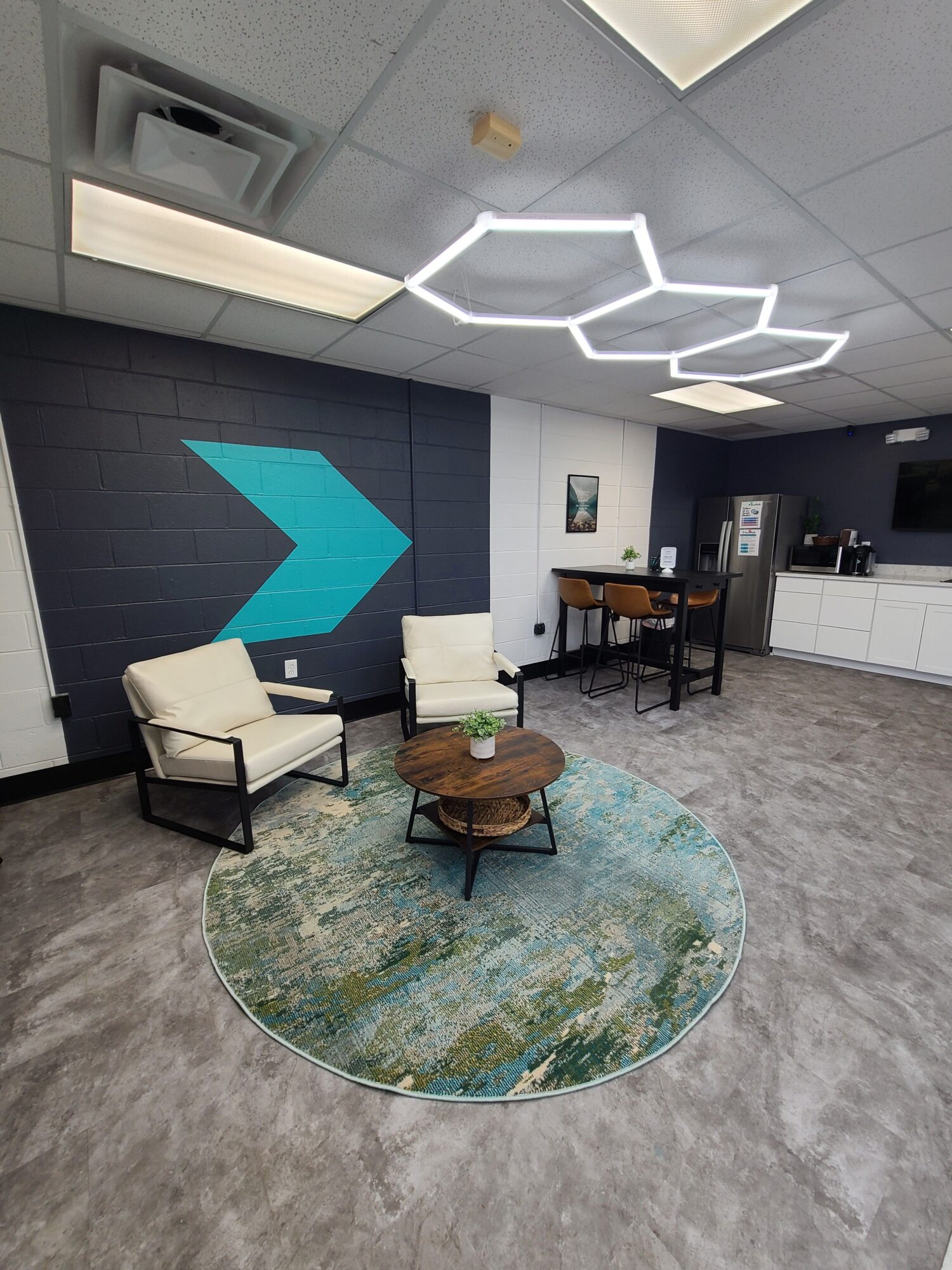 Interior room with modern furniture, a round rug, and decorative lighting on the ceiling.