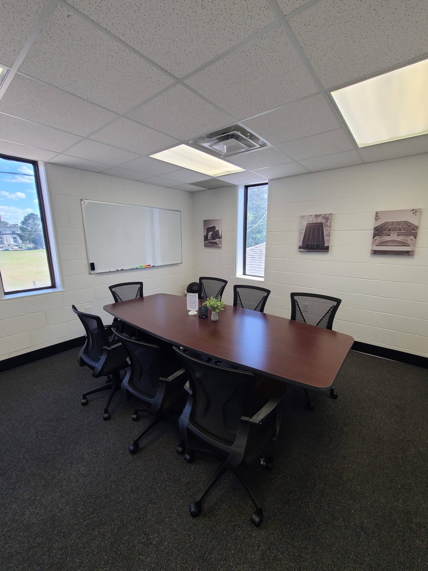 Conference room with a table, chairs, and windows showing outdoor scenery.