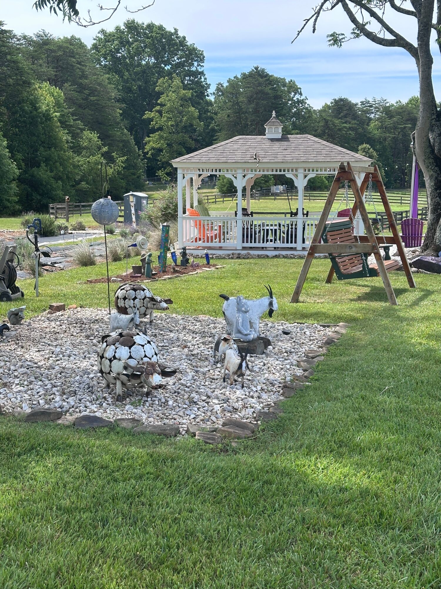 Child playing on a gravel path in a park with playground equipment and trees in the background.