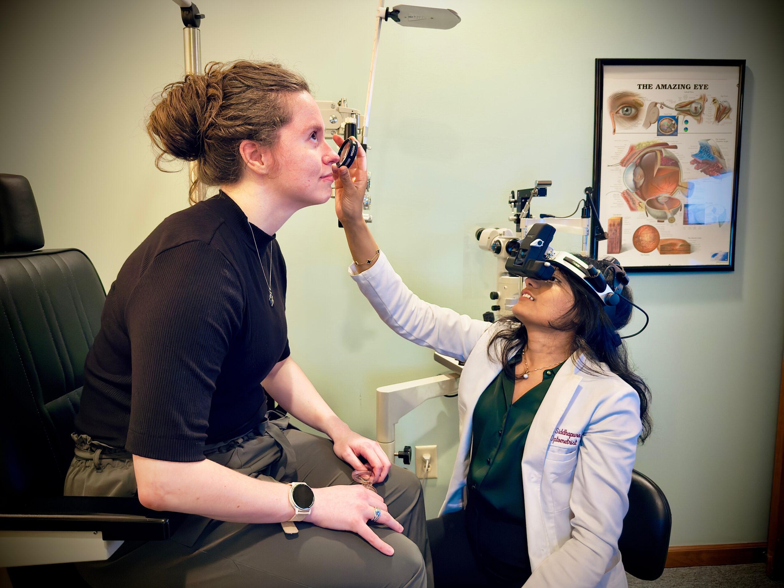 Eye examination in progress with a woman and an eye doctor using a slit lamp, in a clinic room.