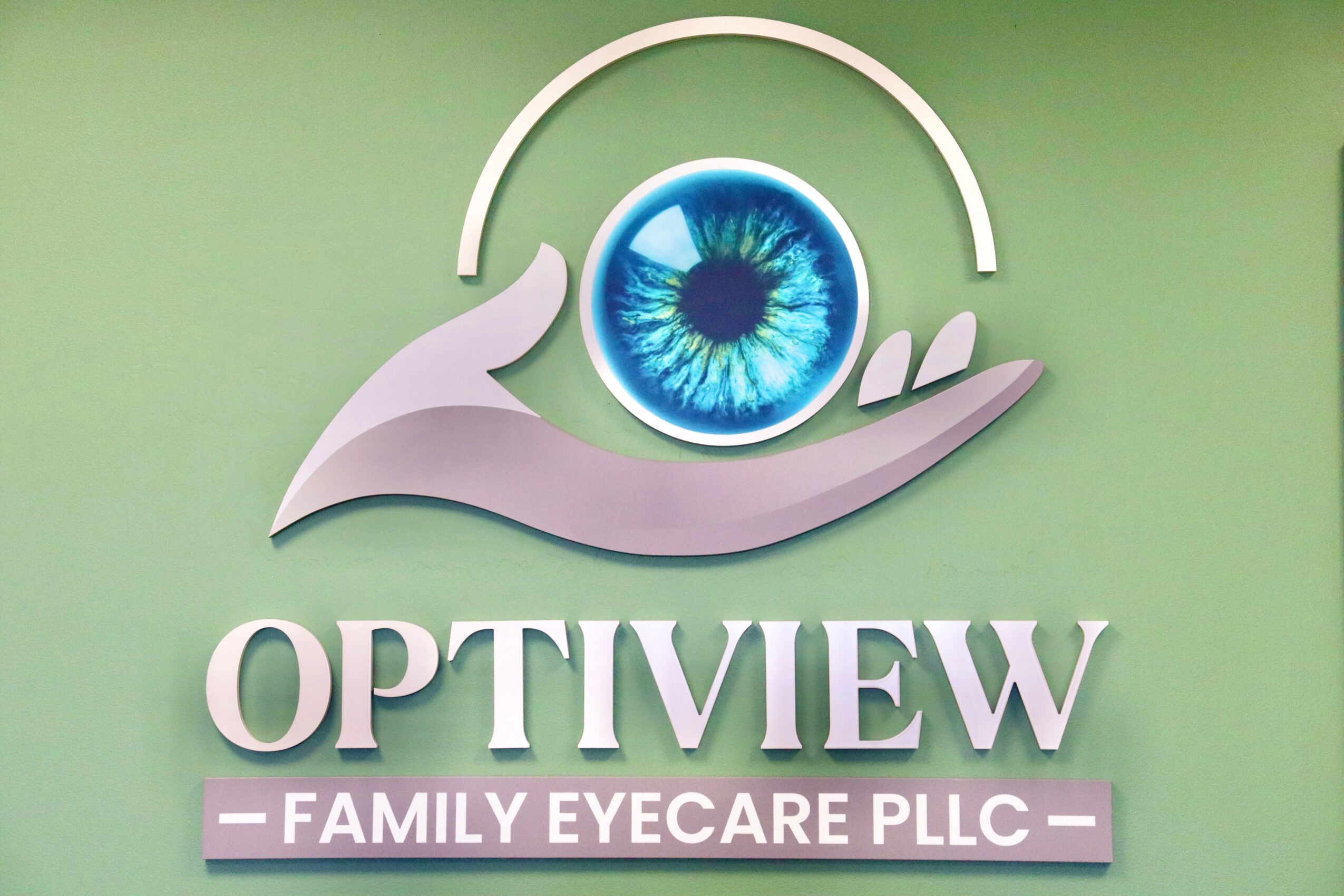 Logo with an eye in a hand and the text 'OPTIVIEW FAMILY EYECARE PLLC' on a green background.