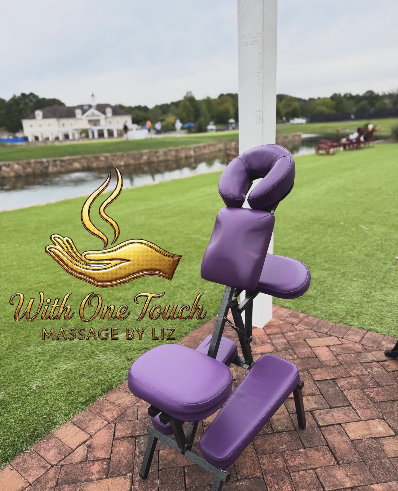 Purple massage chair outdoors on brick path near water and grassy area, with a white pole in background.
