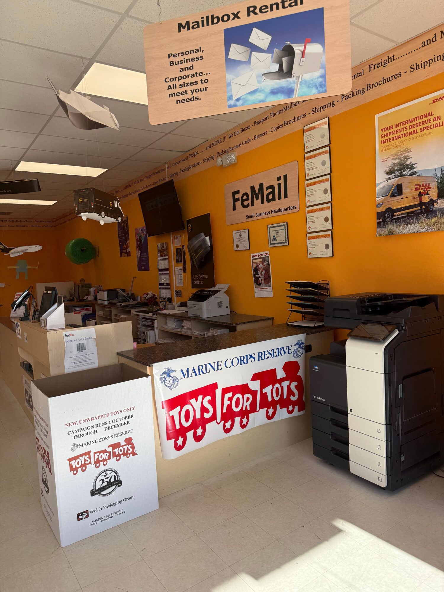 View of a retail counter with promotional signs, a printer, and various items on the counter, seen from the side.