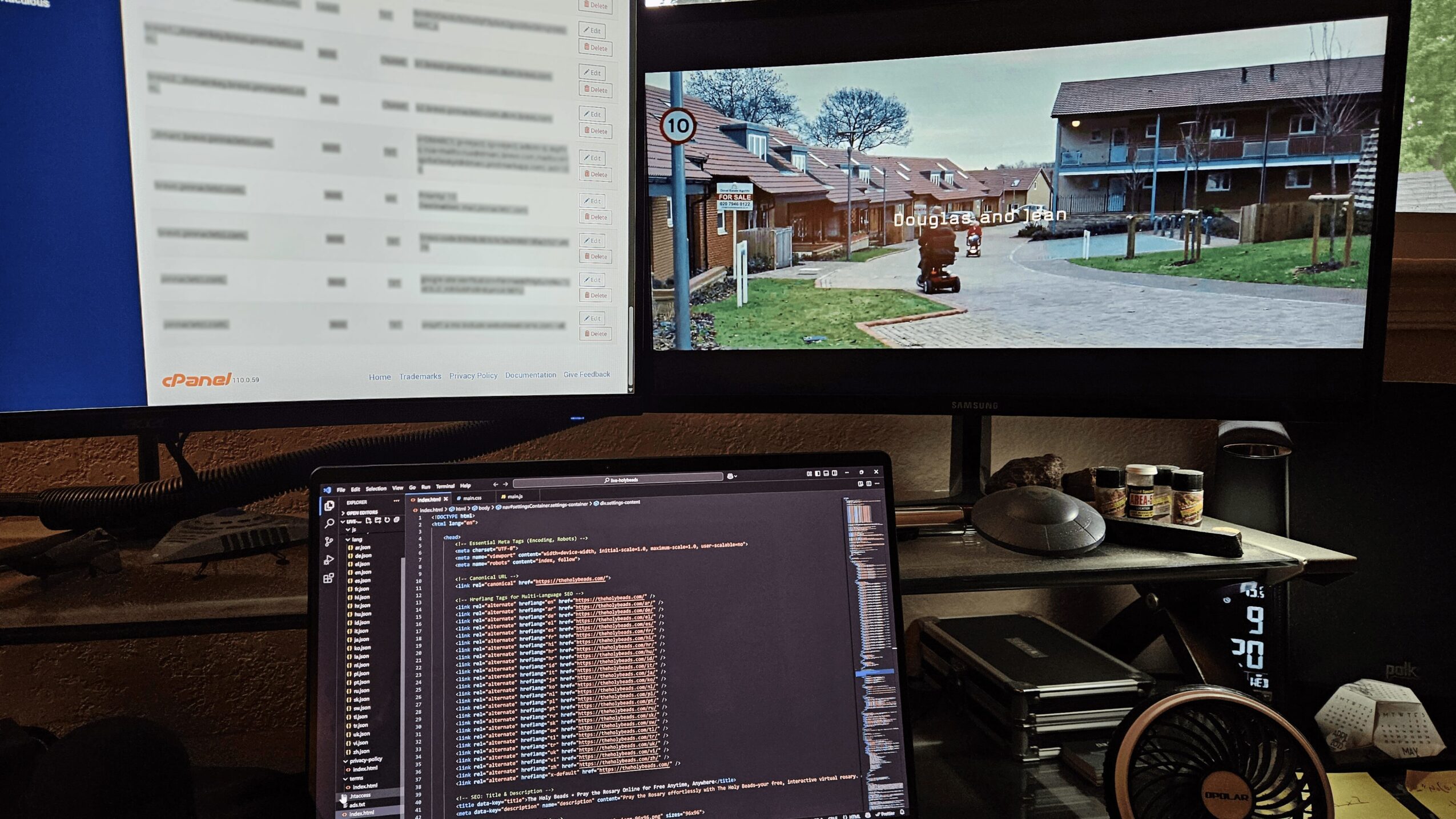 Two monitors displaying a spreadsheet and a street view, with a computer keyboard and other office items on a desk.