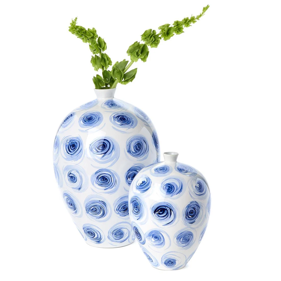 Two white vases with blue circular patterns, one larger with green plant, one smaller, on a white background.