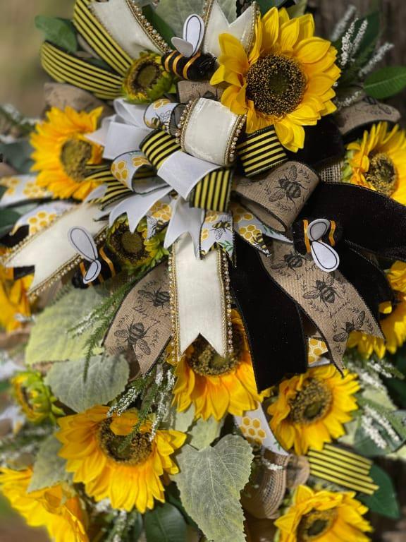 Bouquet of sunflowers with ribbons, leaves, and decorative elements, arranged in a colorful display.