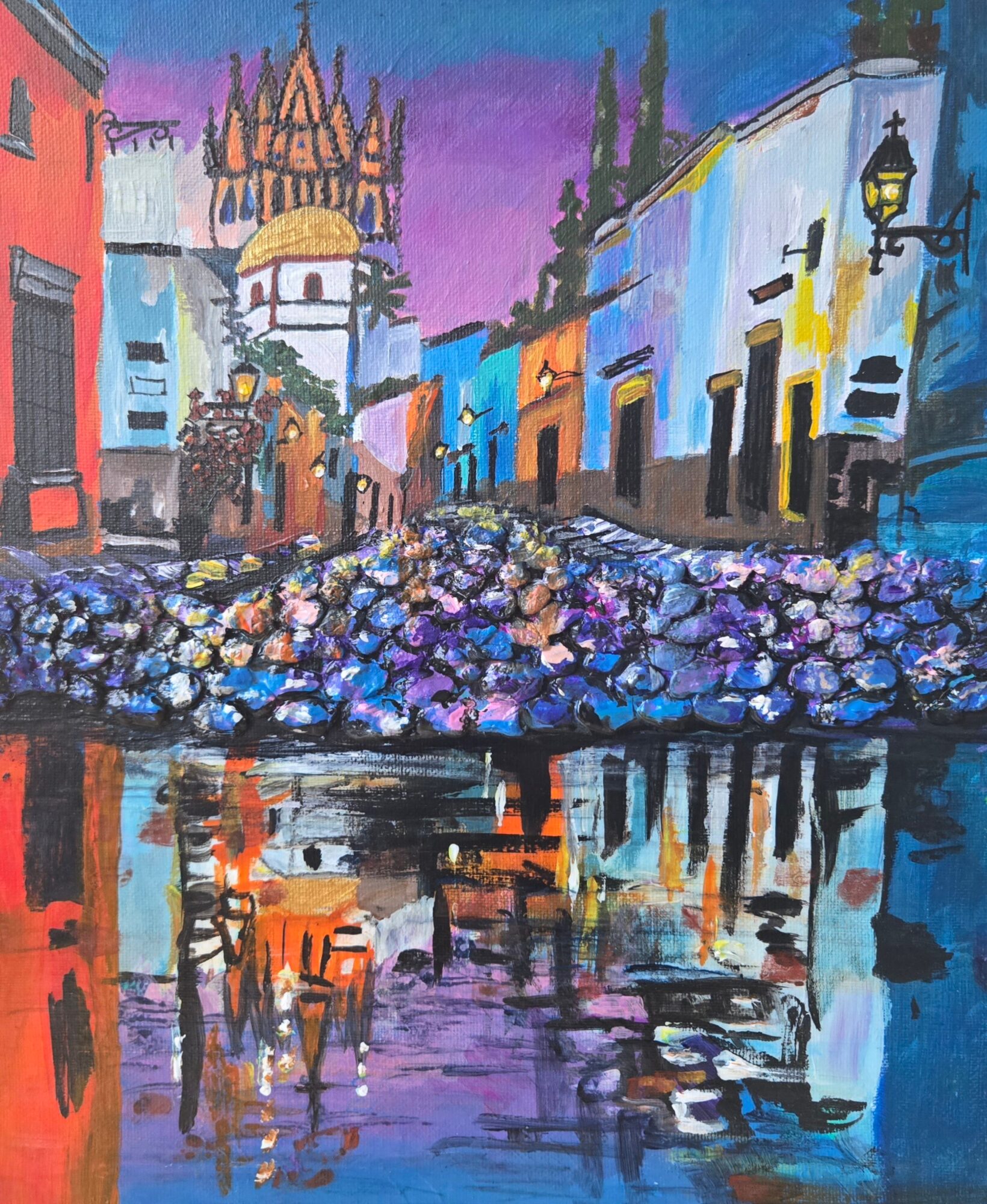 Colorful street scene with buildings, a bridge, and a church in the background, reflected in water, painted in vibrant colors.