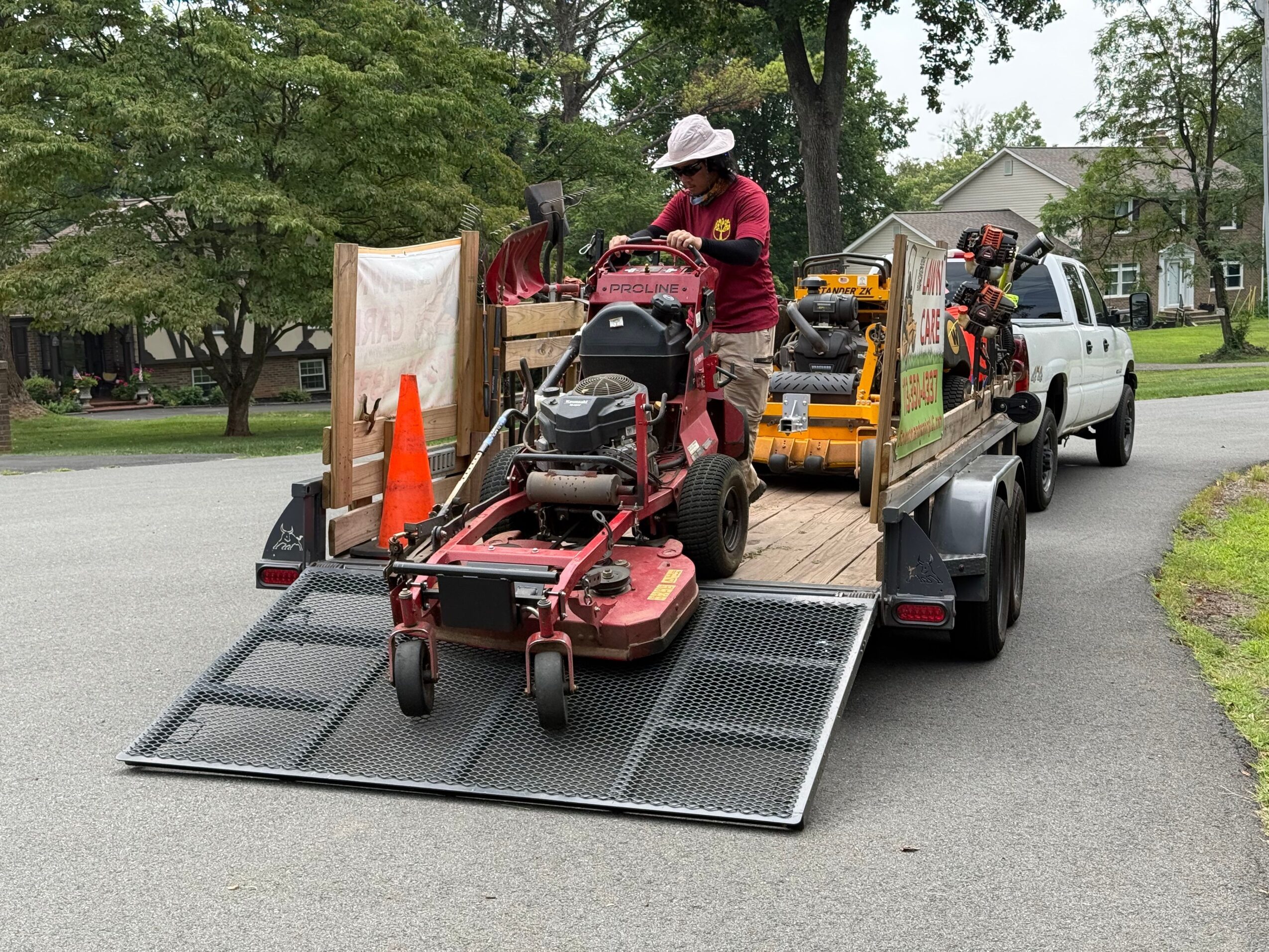 Person loading items onto a truck with a solar panel, surrounded by trees and grass, in an outdoor setting.