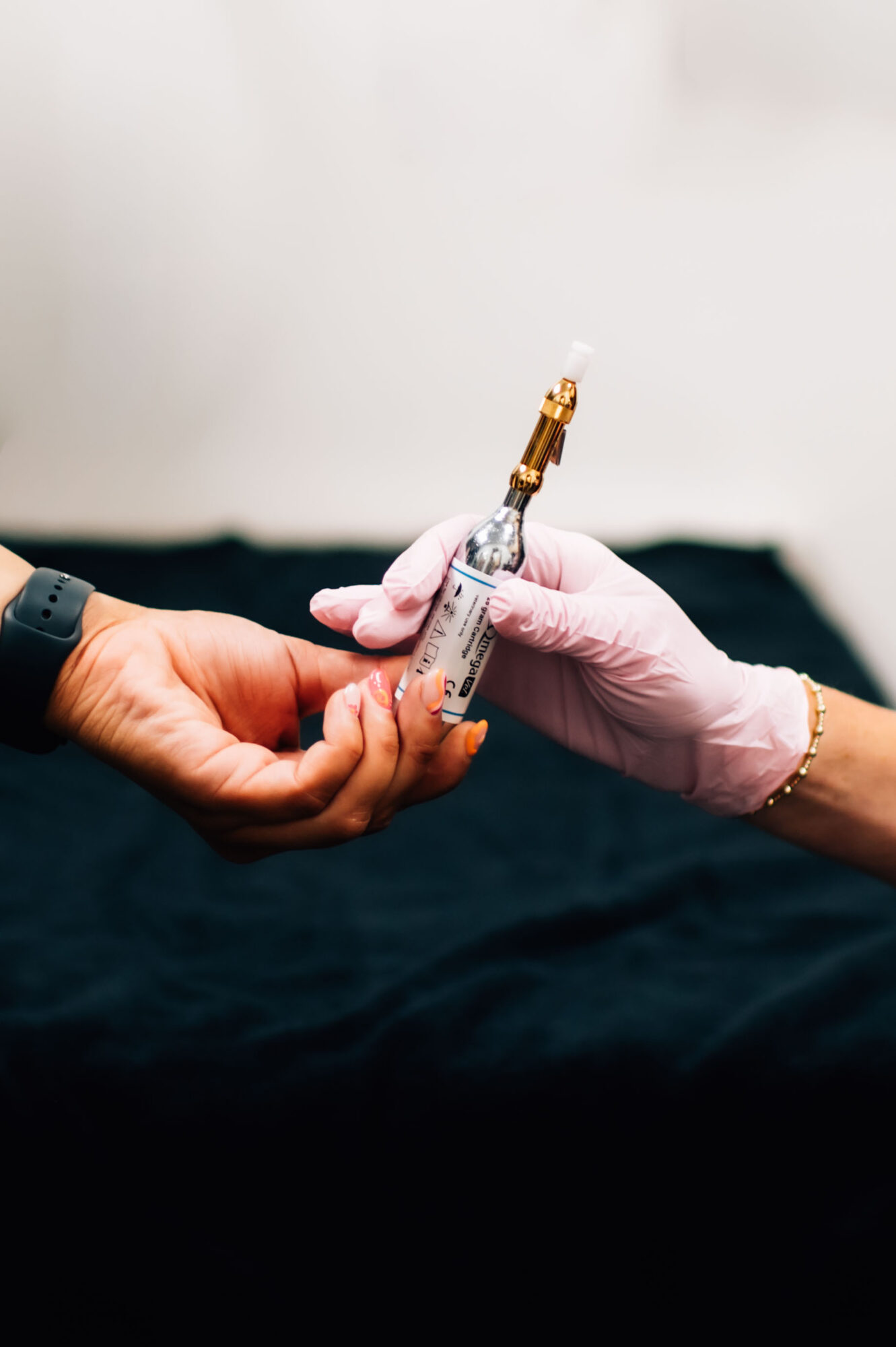 Person receiving a vaccine injection from healthcare worker wearing gloves, hand holding syringe, background blurred