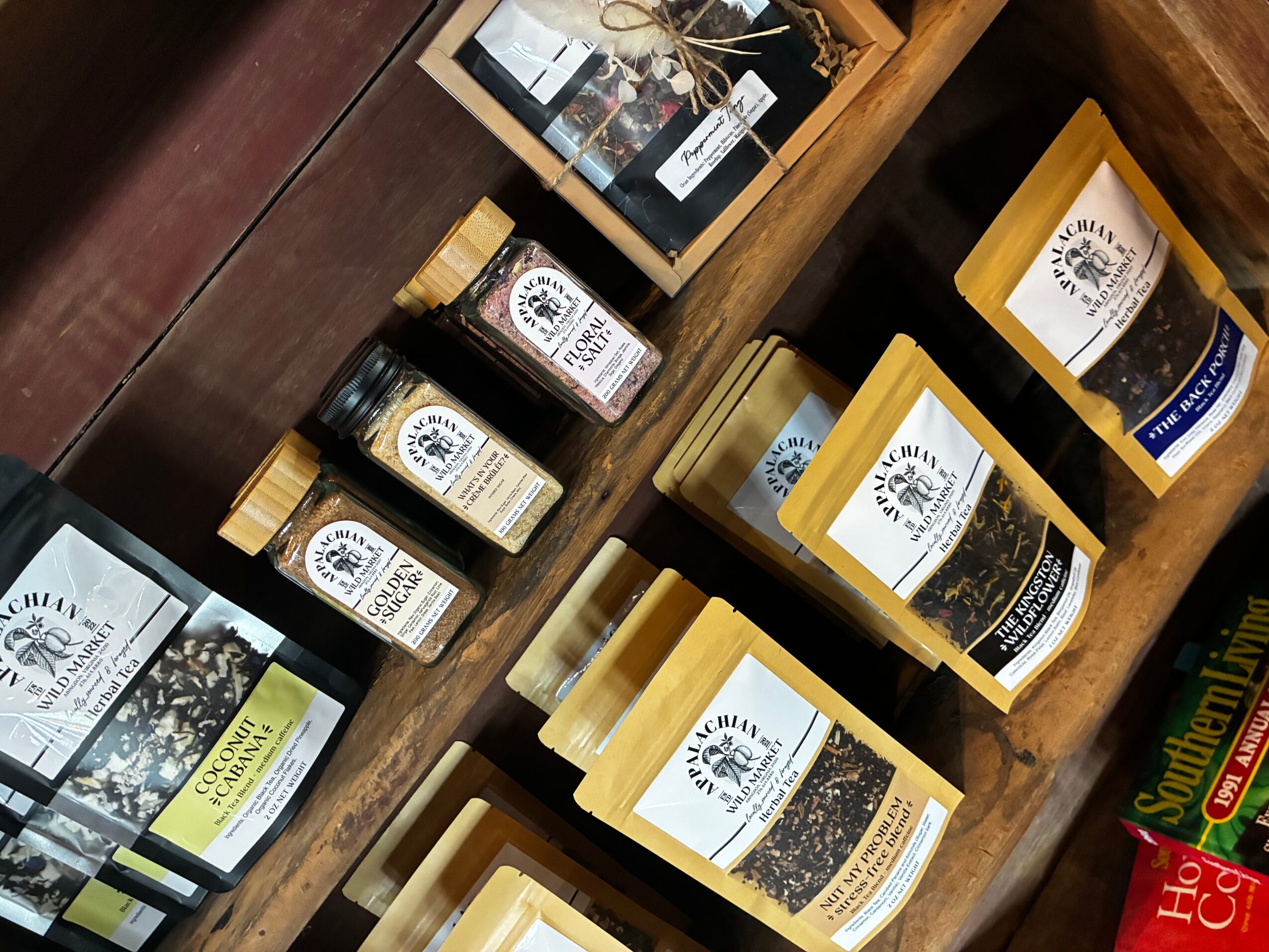 Display of packaged coffee products on wooden shelves with labels and branding visible.