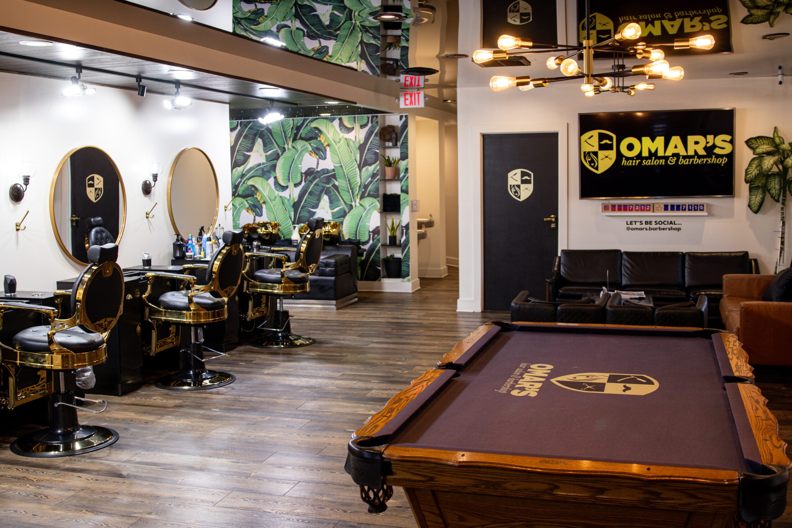 Barber shop with chairs, mirrors, and a mural wall, adjacent to a pool table and a sign for Omar's.
