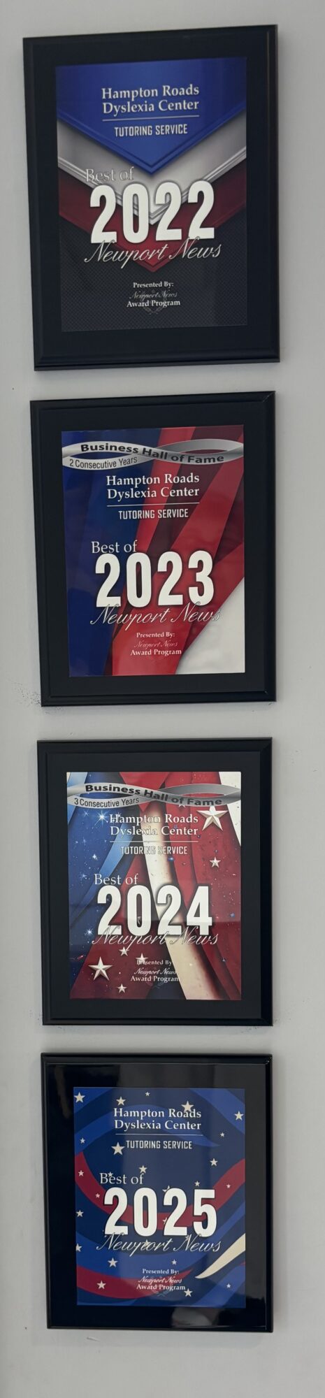 Four framed posters displaying years 2022, 2023, 2024, and 2025 with abstract backgrounds.