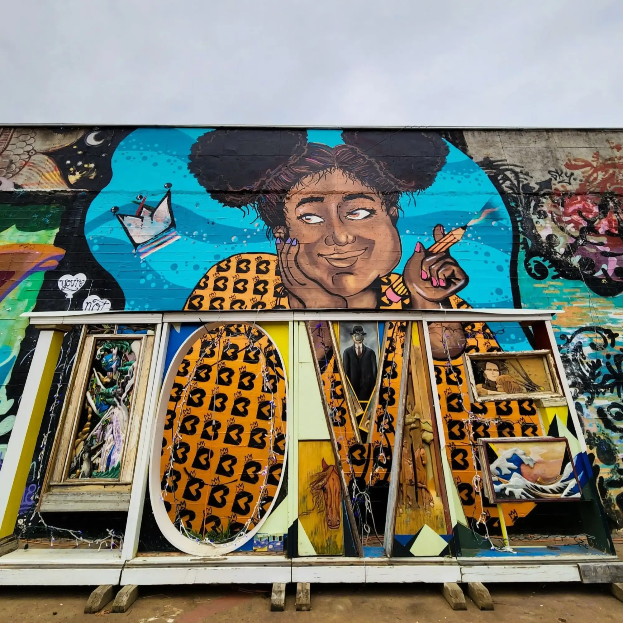 Colorful mural of a girl with puffy hair, holding a cigarette, with vibrant background and graffiti elements.