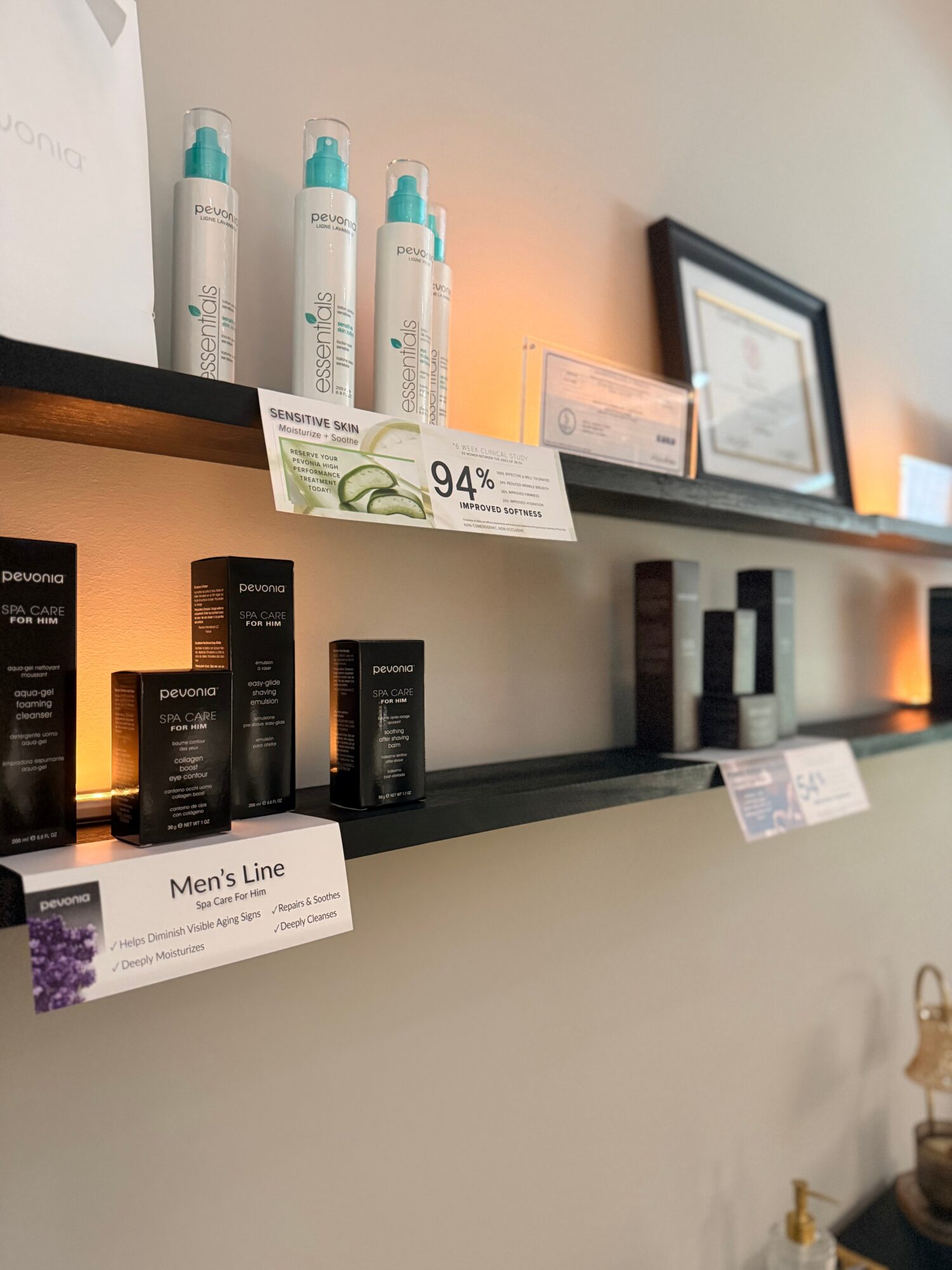 Shelves with skincare and haircare products, framed picture, and labels, in a retail or salon setting.