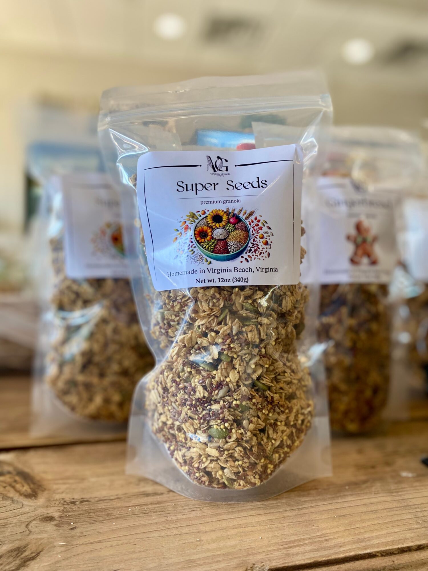 Clear plastic bag labeled 'Super Seeds' with sunflower seed mixture, standing on a wooden surface, with other bags in background.