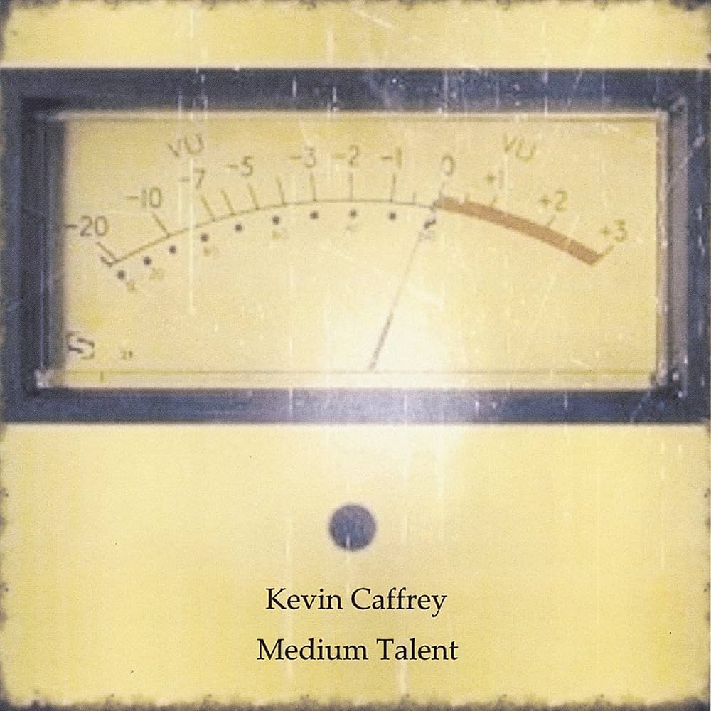 Analog meter with a needle pointing slightly to the right, labeled with decibel levels, and text reading 'Kevin Caffrey Medium Talent'.