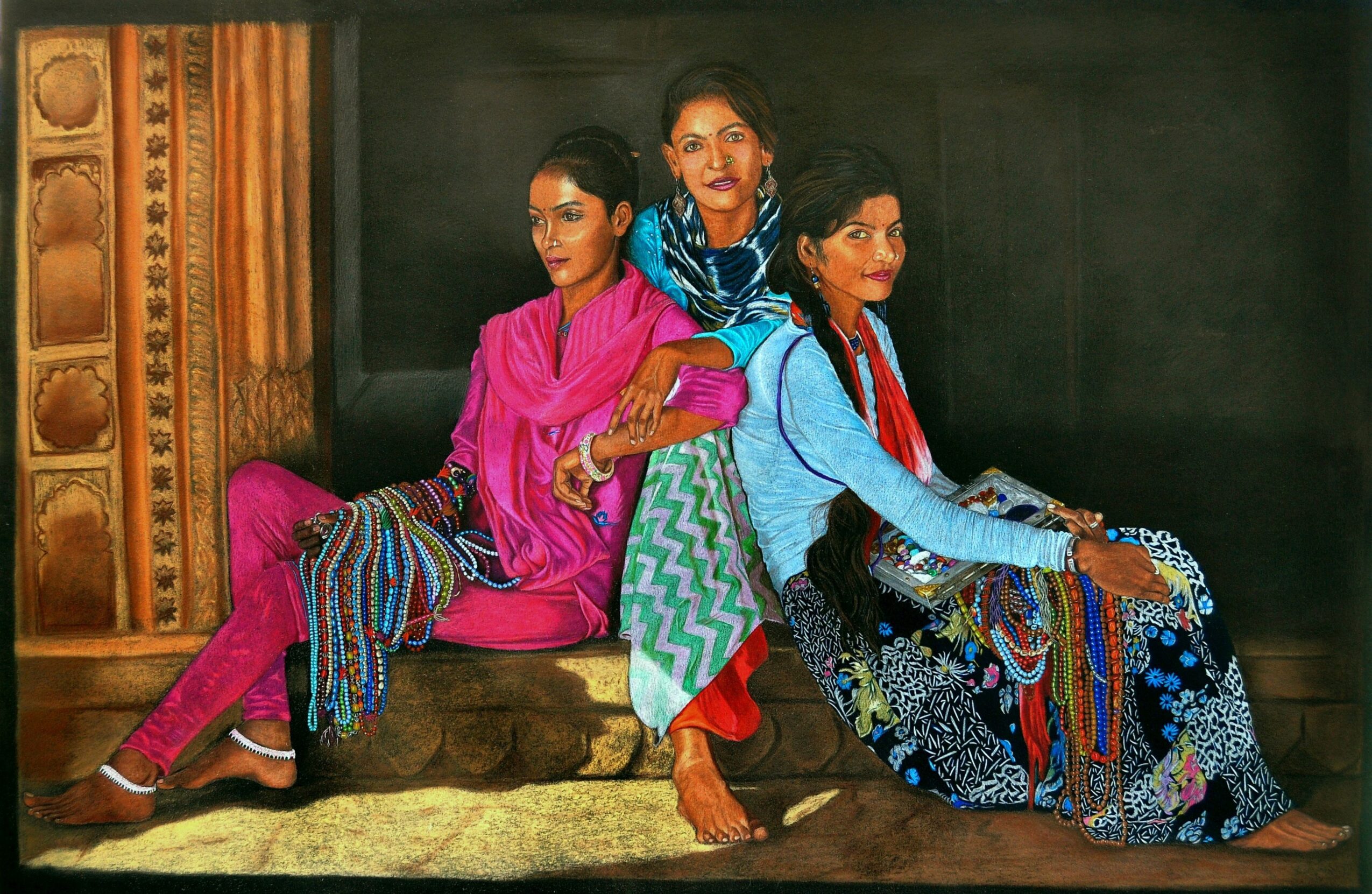 Three women sit on a bench, dressed in colorful traditional clothing, against a dark background.