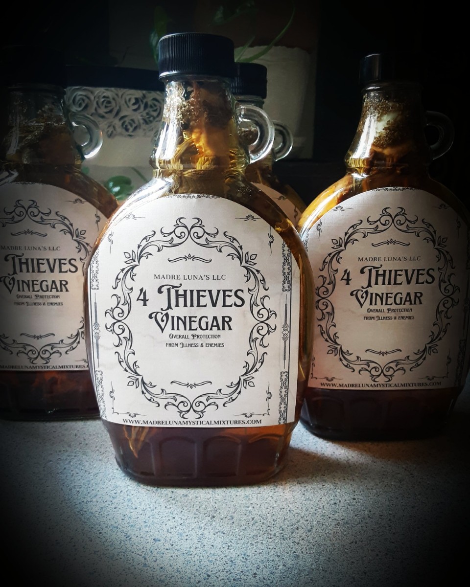 Three bottles of 4 Thieves Vinegar with labels, placed on a surface with a dark background.