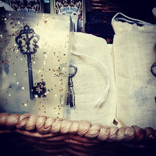 Decorative key with glitter, two fabric bags, and a woven basket, with a store background.
