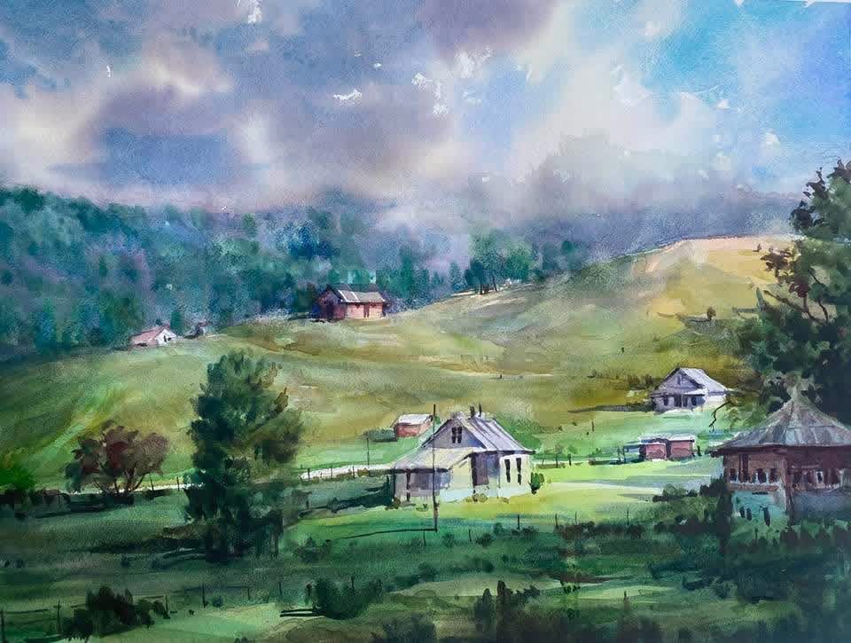 Watercolor painting of a rural landscape with houses, trees, green hills, and a cloudy sky.