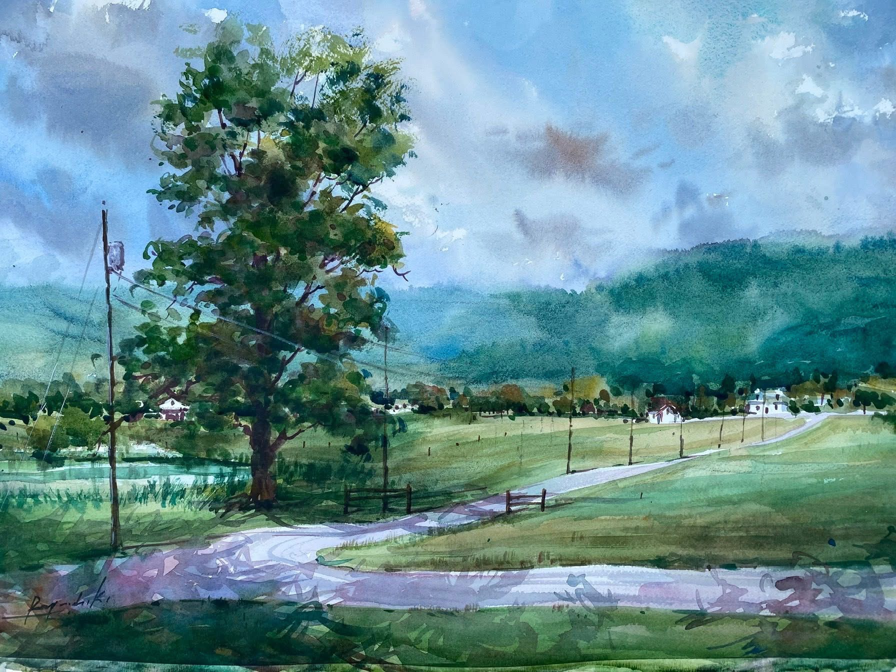Landscape with a large tree, grassy field, pathway, and distant hills under cloudy sky.