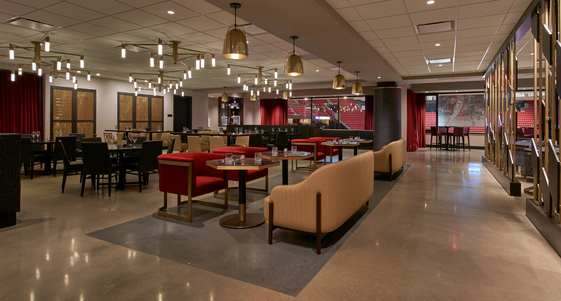 Elegant restaurant interior with tables, chairs, and modern lighting fixtures, featuring large windows and red curtains.