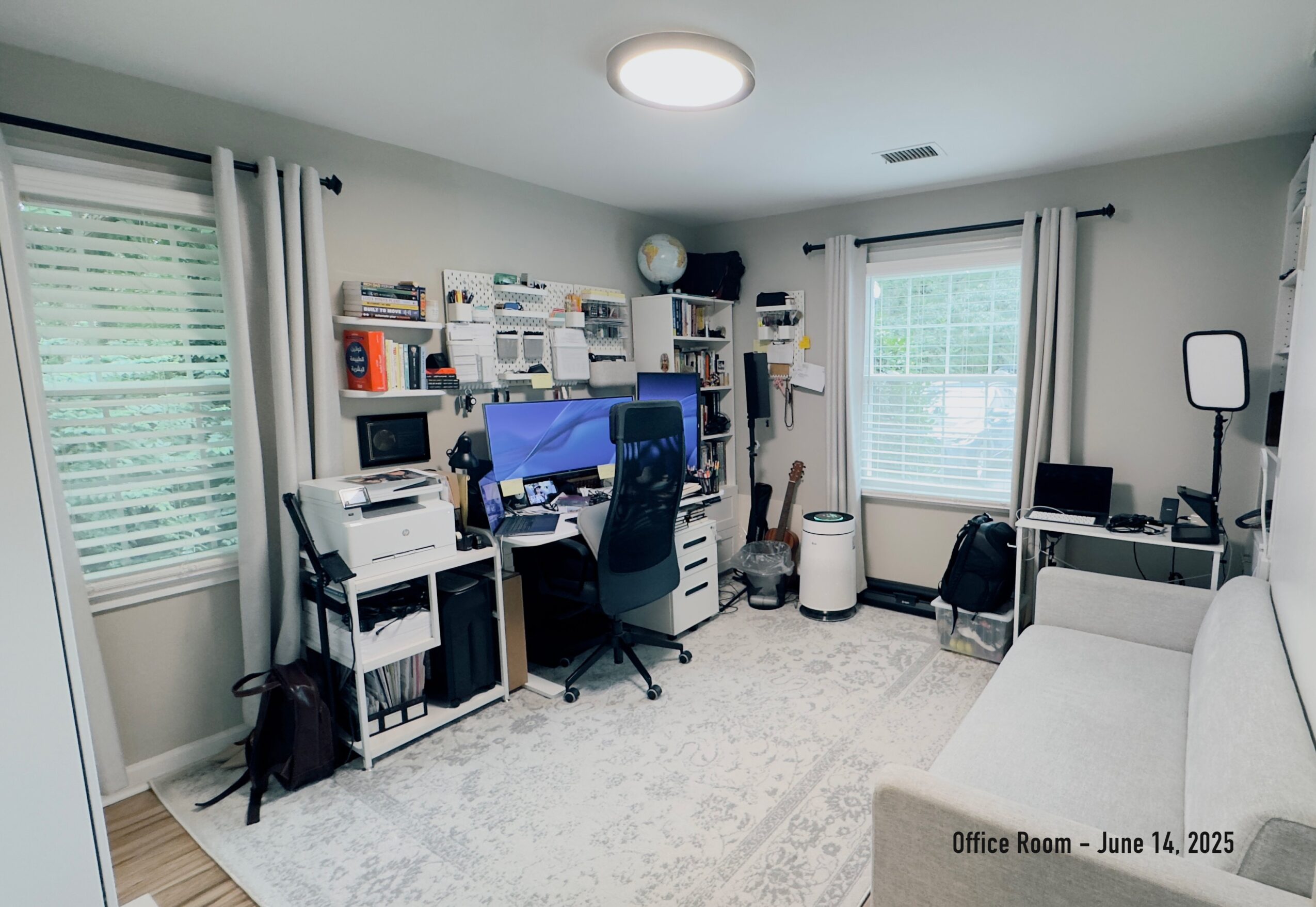 Home office with desk, chair, shelves, and window, organized workspace with natural light, light-colored walls and carpet.
