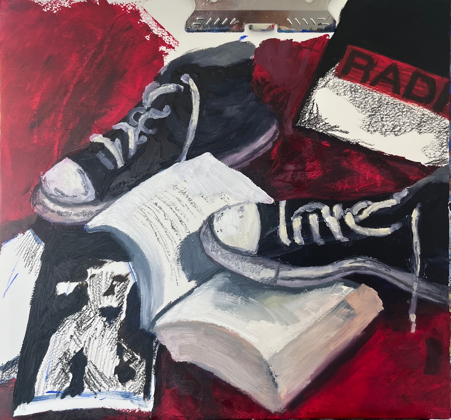 Sneaker, book, and a bag with 'RAD' on it on a red surface, with a photograph of a dog, and a keyboard in the background.