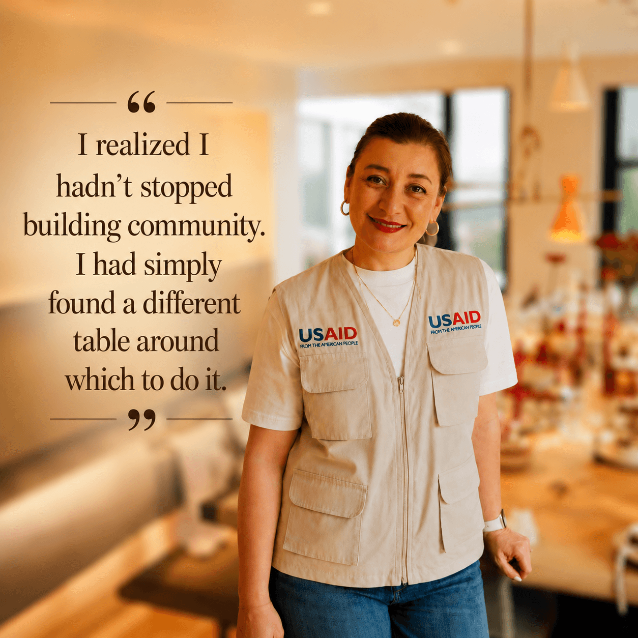 Woman in a vest with USAID logo smiling in a bright indoor space, with a quote about building community.