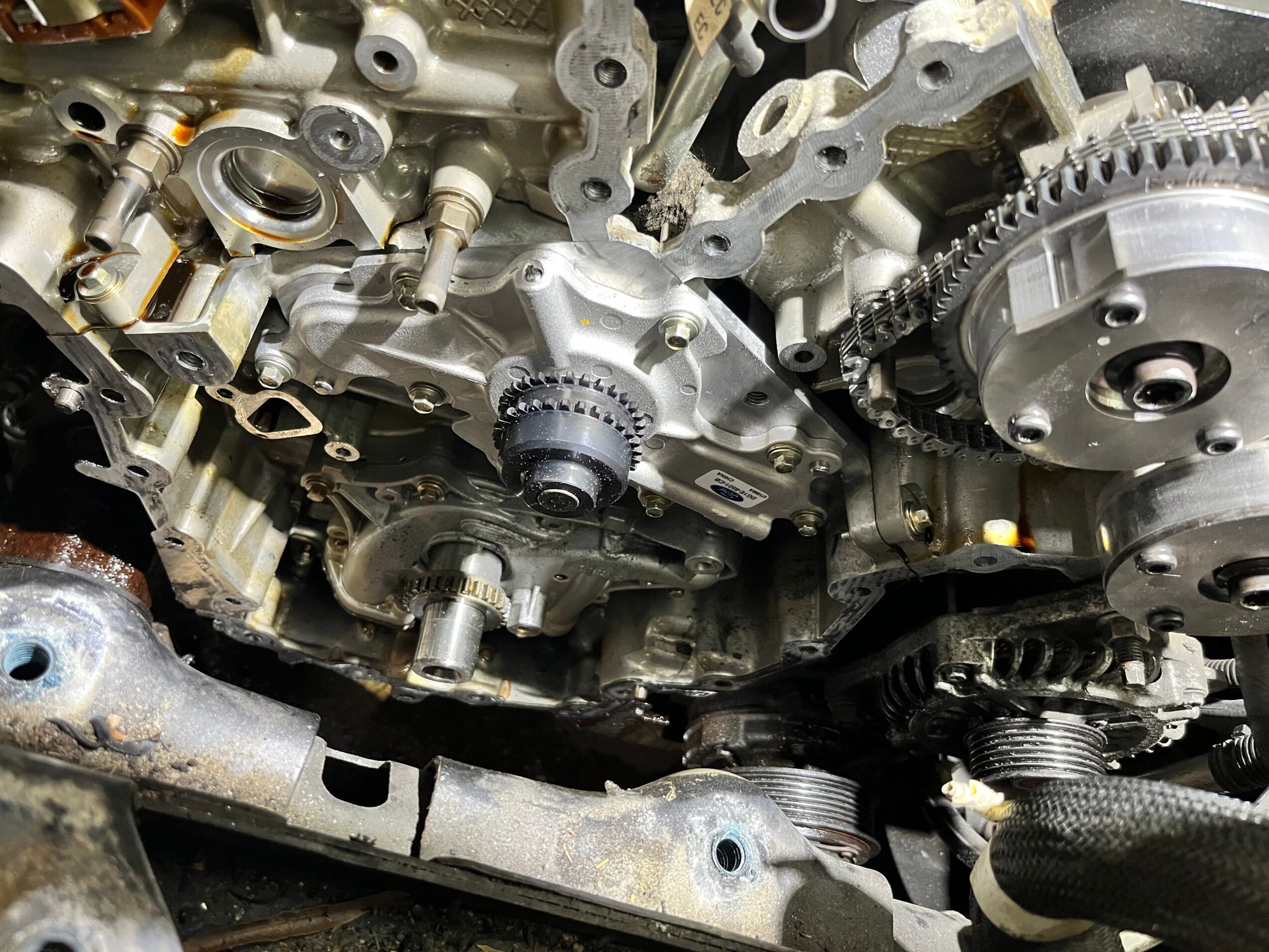 Close-up of an engine's internal mechanical parts, including gears, chains, and metal components.