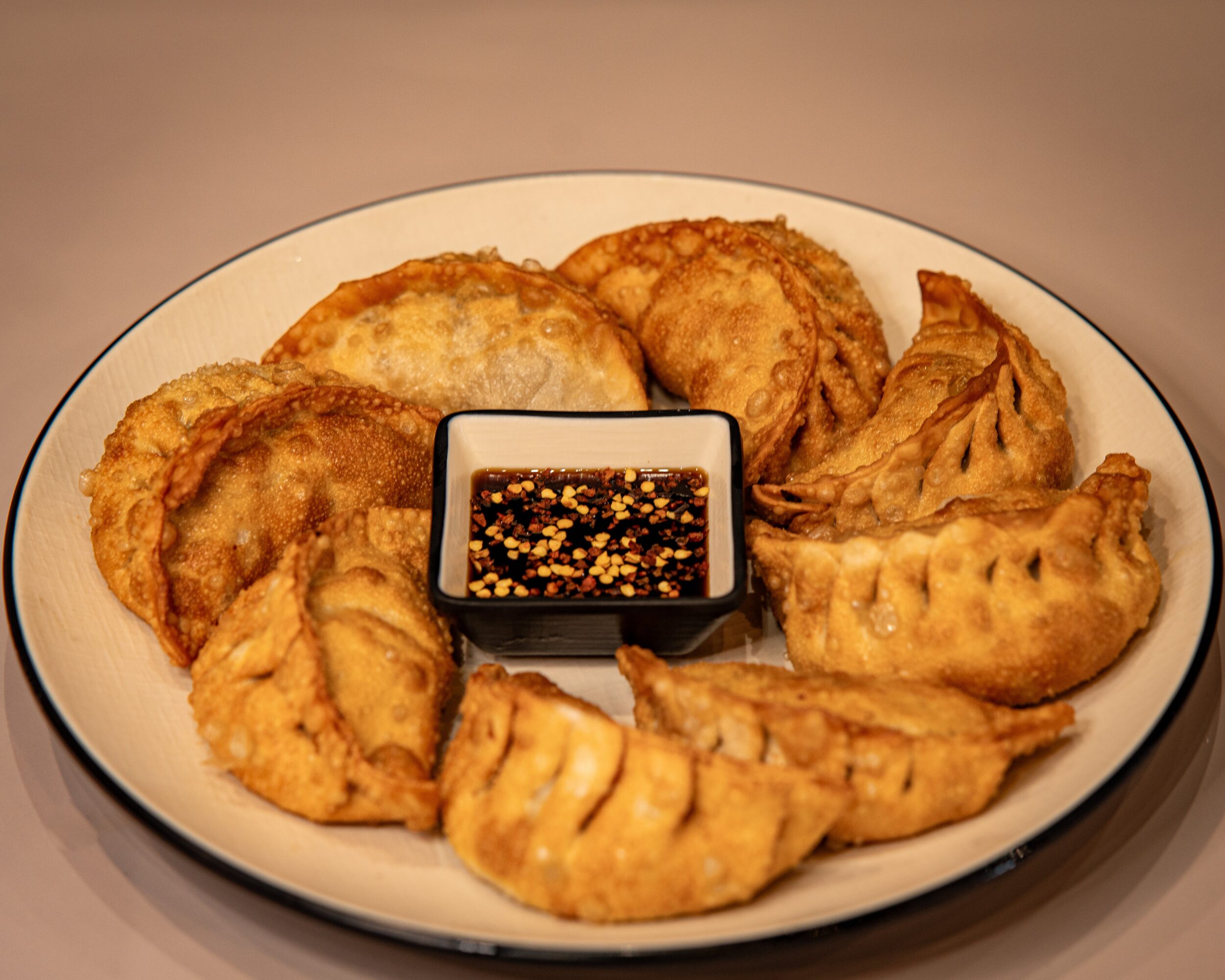 Plate with assorted fried foods and a small container of dipping sauce in the center.
