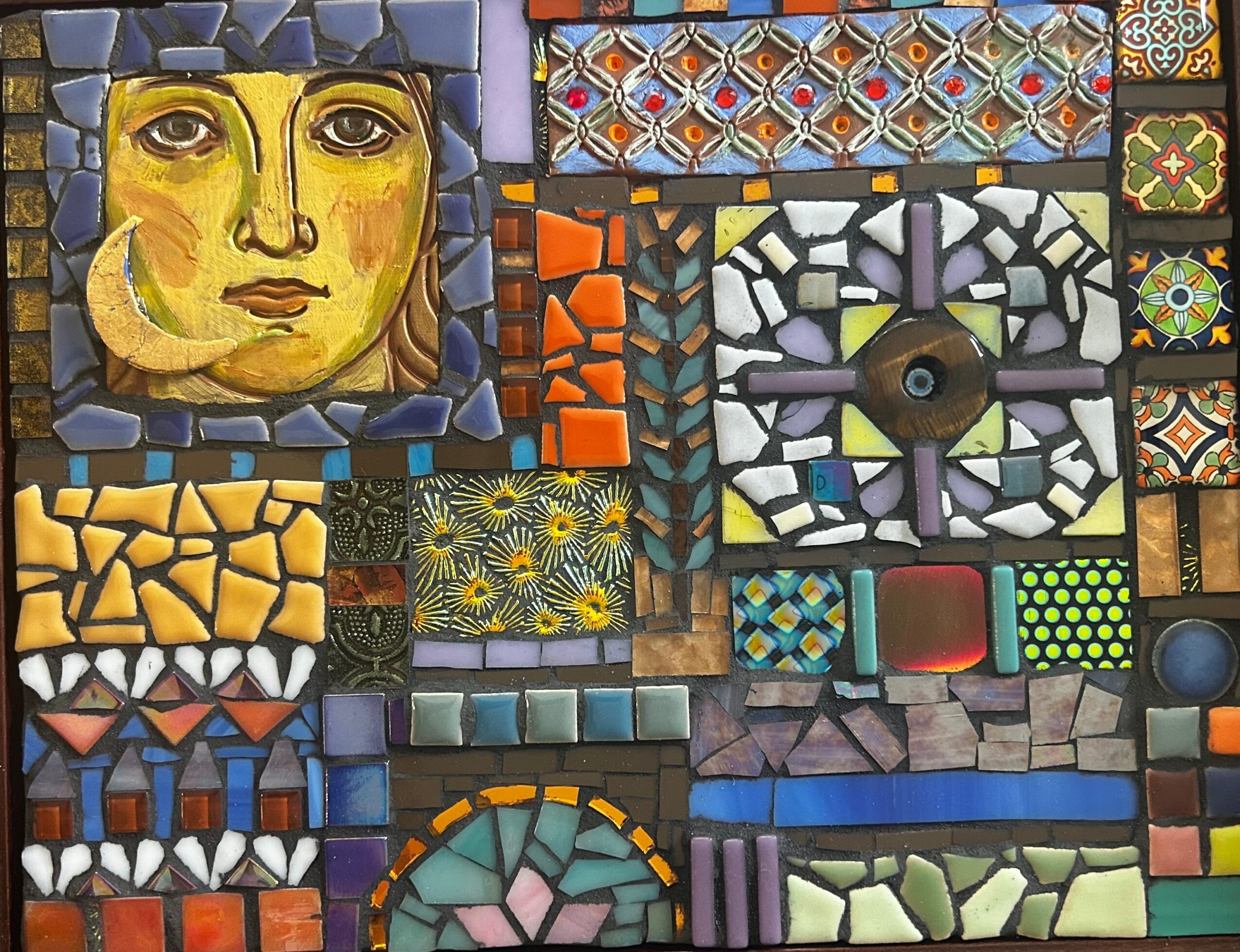 Colorful mosaic artwork with a woman's face, geometric patterns, and various tile designs, arranged in a vibrant collage.