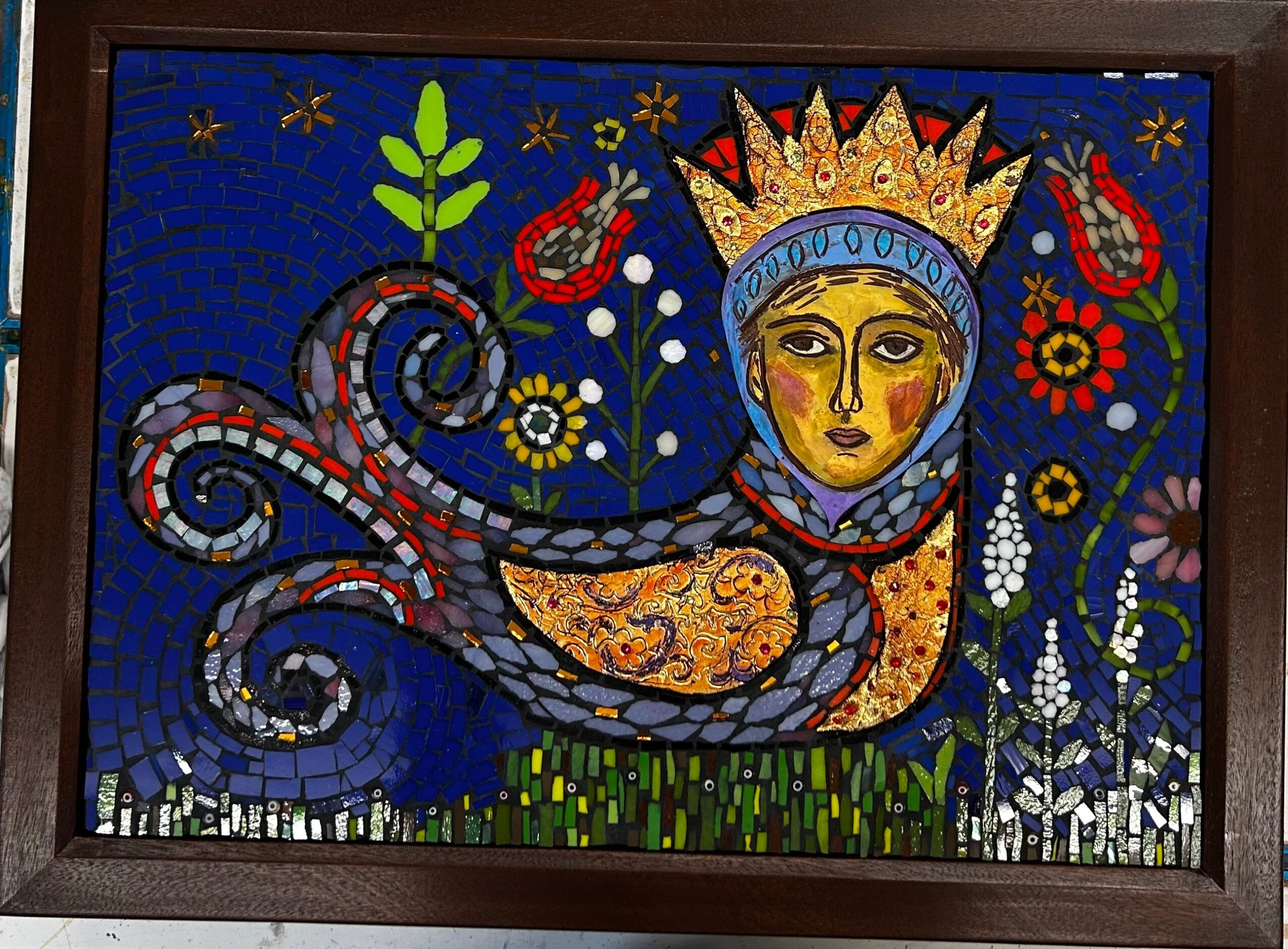 Colorful mosaic of a woman with a crown, surrounded by flowers and decorative patterns, on a blue background.