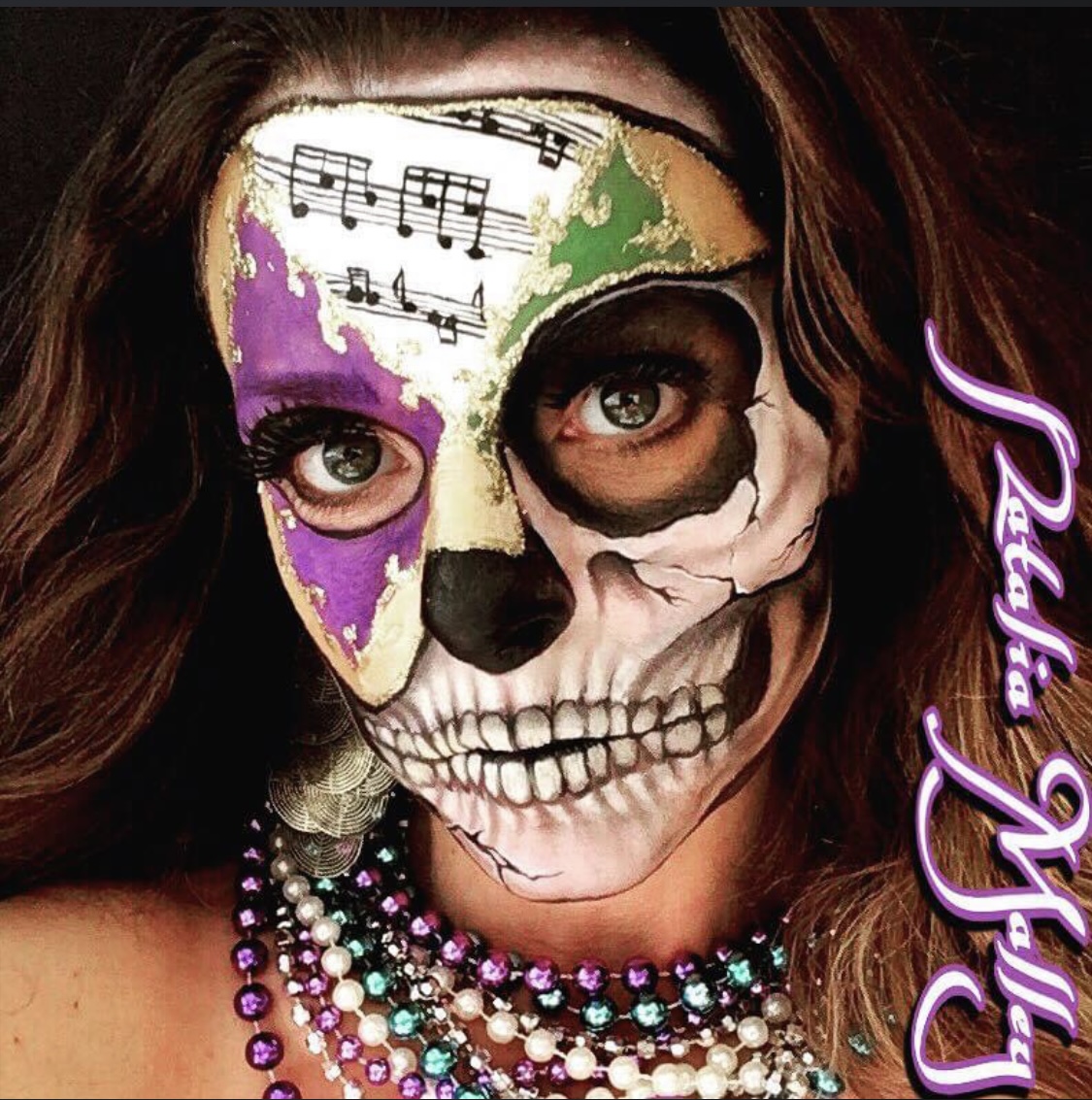 Person with face painted as a skull, decorated with music notes, wearing colorful necklaces, and a purple neon sign reading 'Glam Girl'.