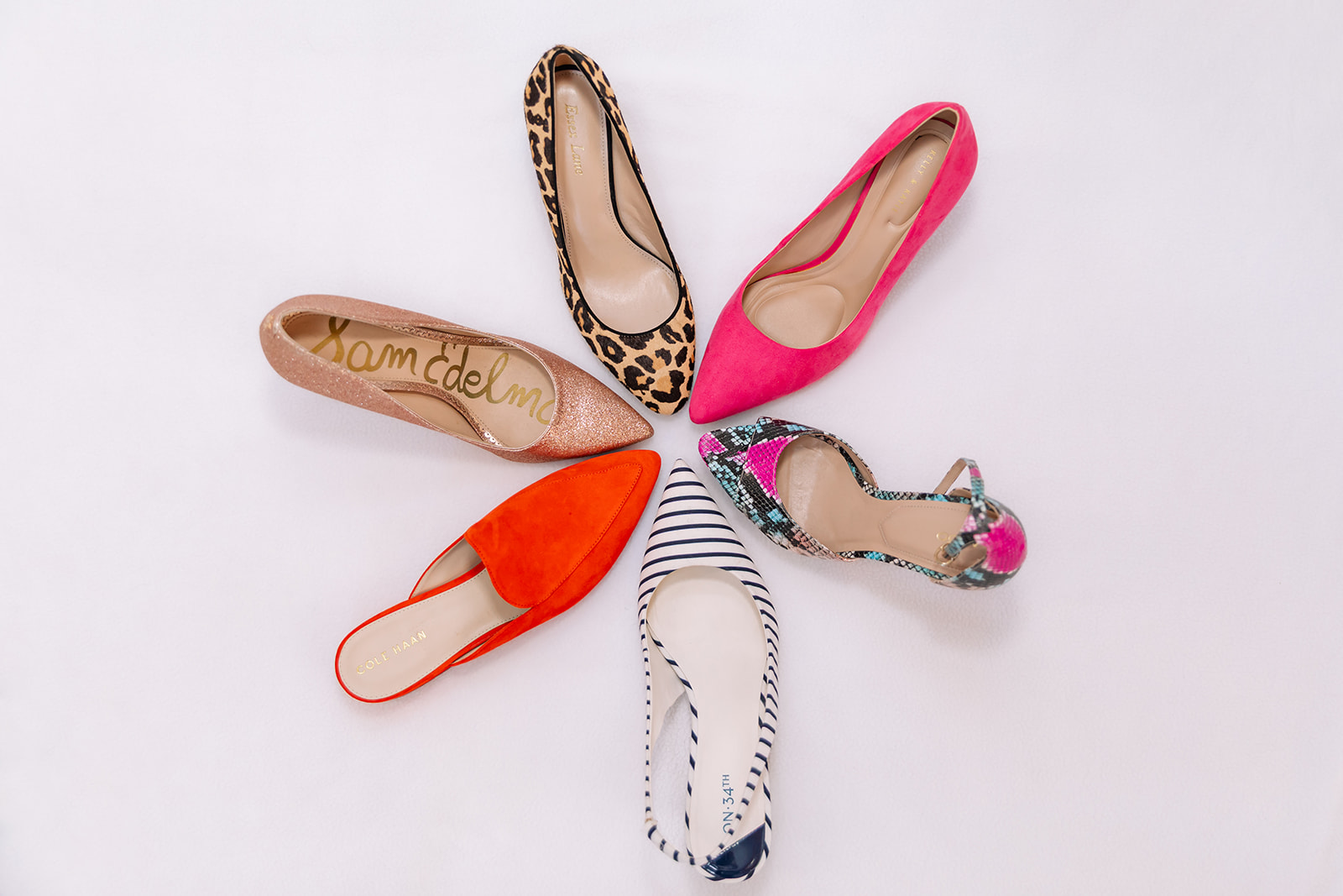 Six women's shoes arranged in a circle on a white background, including leopard print, pink, red, and patterned shoes.
