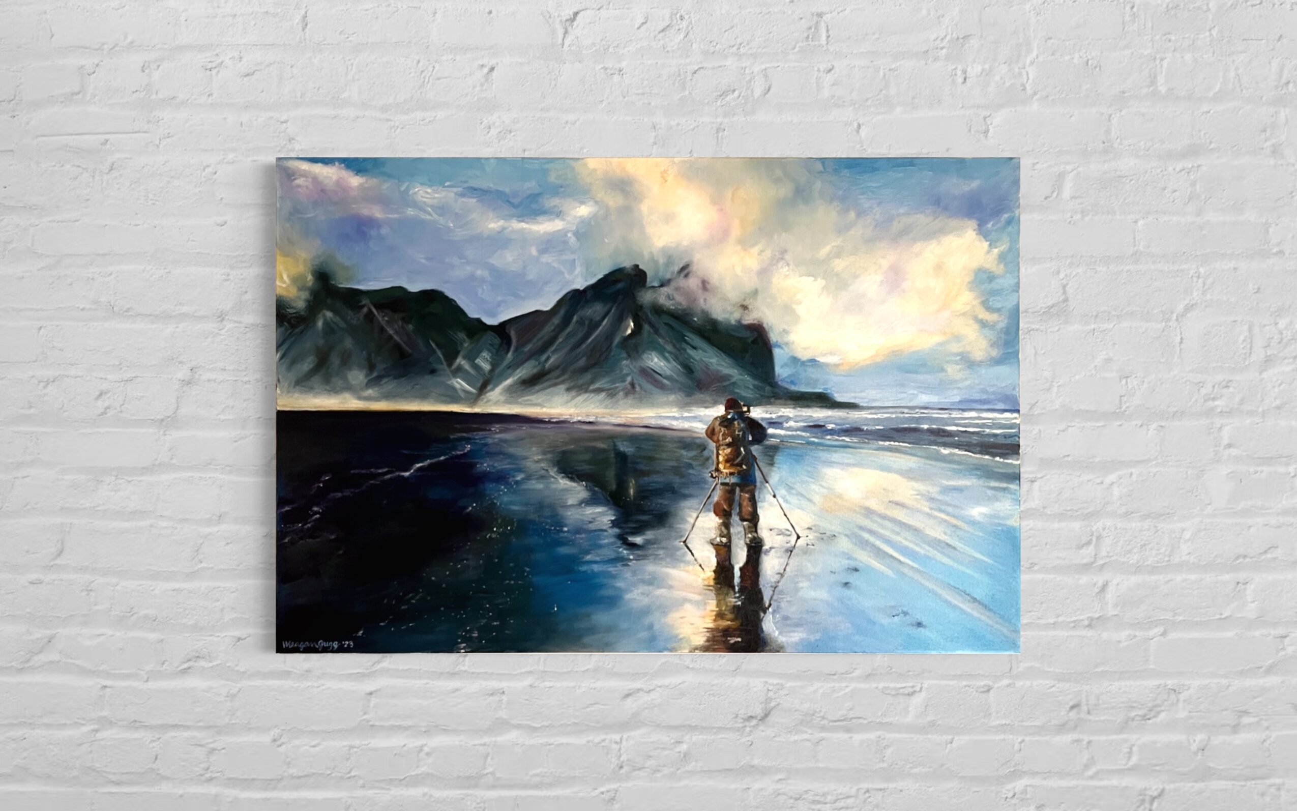 Painting of a person walking on a beach with mountains and sky in the background, reflected in wet sand.