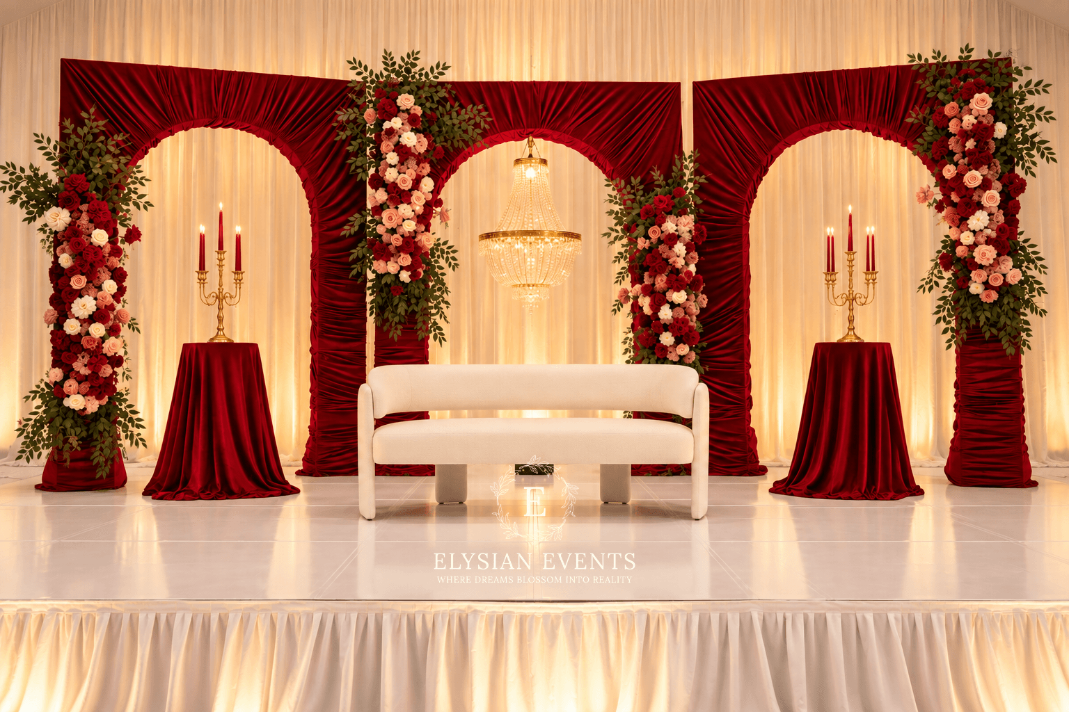 Decorated stage with floral arrangements, candles, and a white bench, set for a wedding or event, with red and white color theme.
