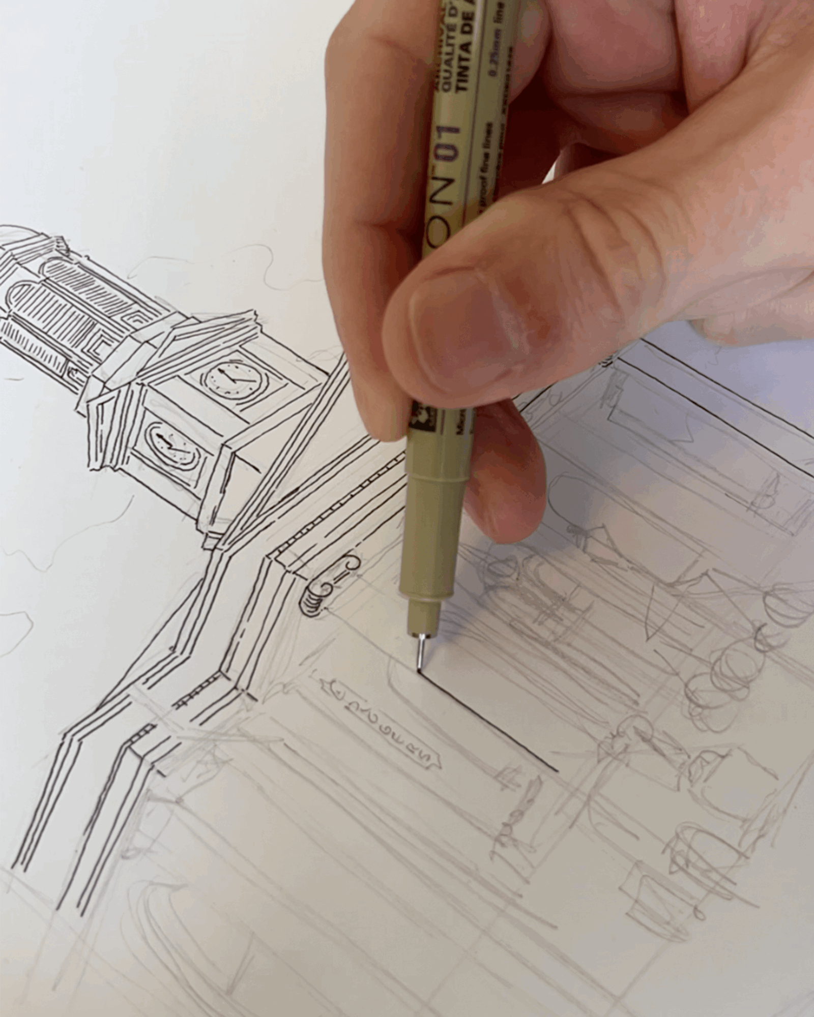 Hand holding a pen drawing a technical sketch of machinery or equipment on paper.
