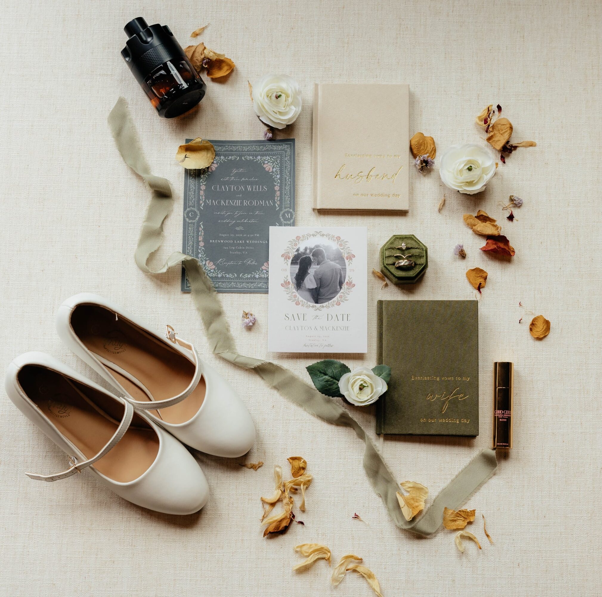 Flat lay of white shoes, perfume, books, flowers, and a camera on a light surface.