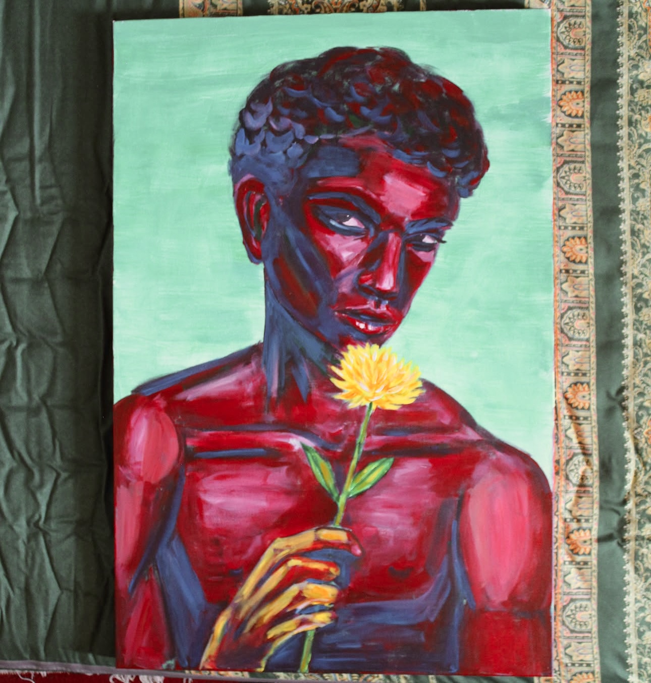 Portrait of a person with short hair holding a yellow flower, painted with bold red and blue brushstrokes, against a green background.