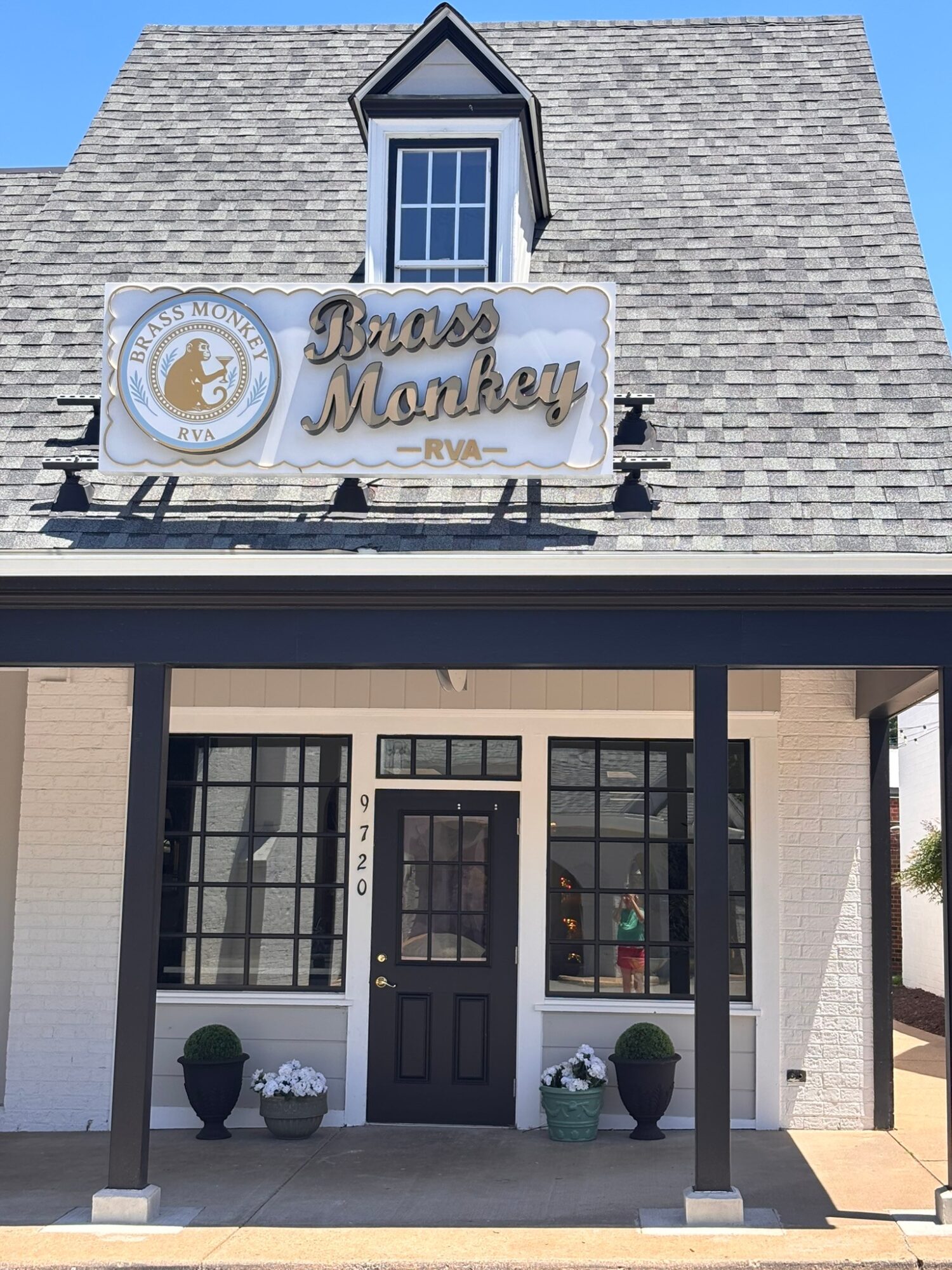 Building with a sign reading 'Bronx Monkey' and a small front porch with potted plants.
