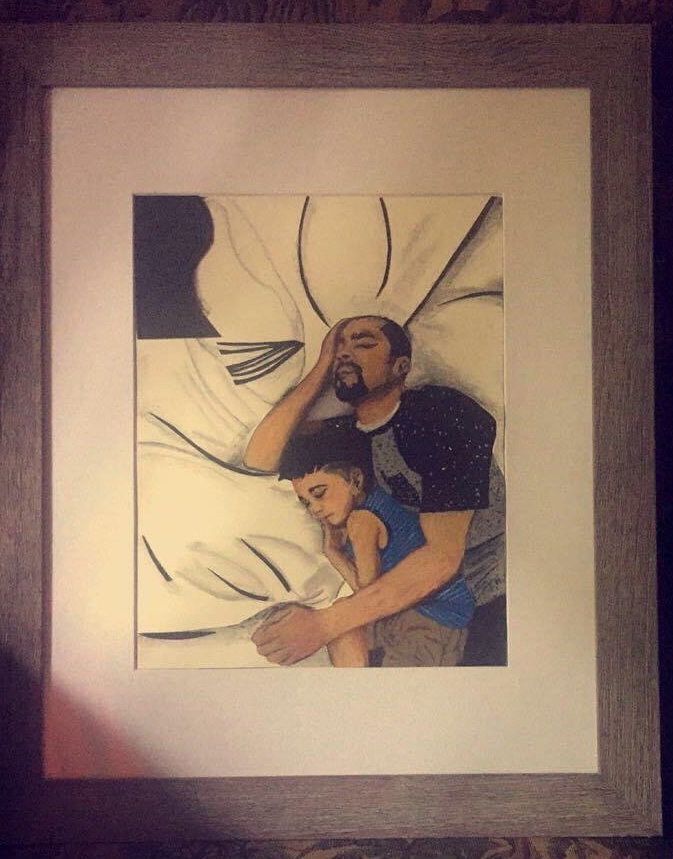 A framed painting of a man and a child lying on a bed, with the man holding a phone to his ear.