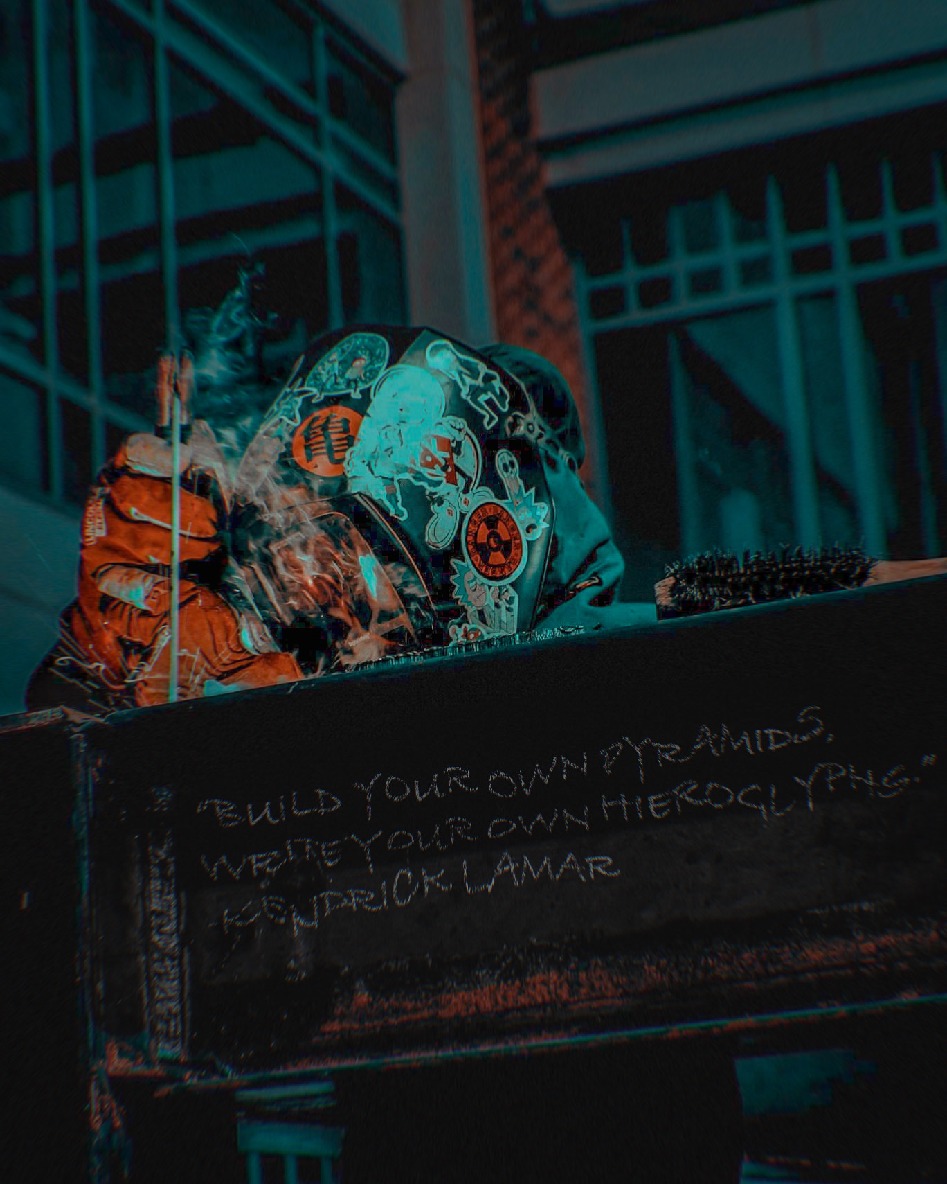 A firefighter helmet with stickers and a mask, with a blackboard displaying handwritten text, in an industrial setting.