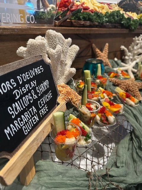 Decorative holiday treats on a wire rack with starfish and coral, with a sign and green fabric nearby.